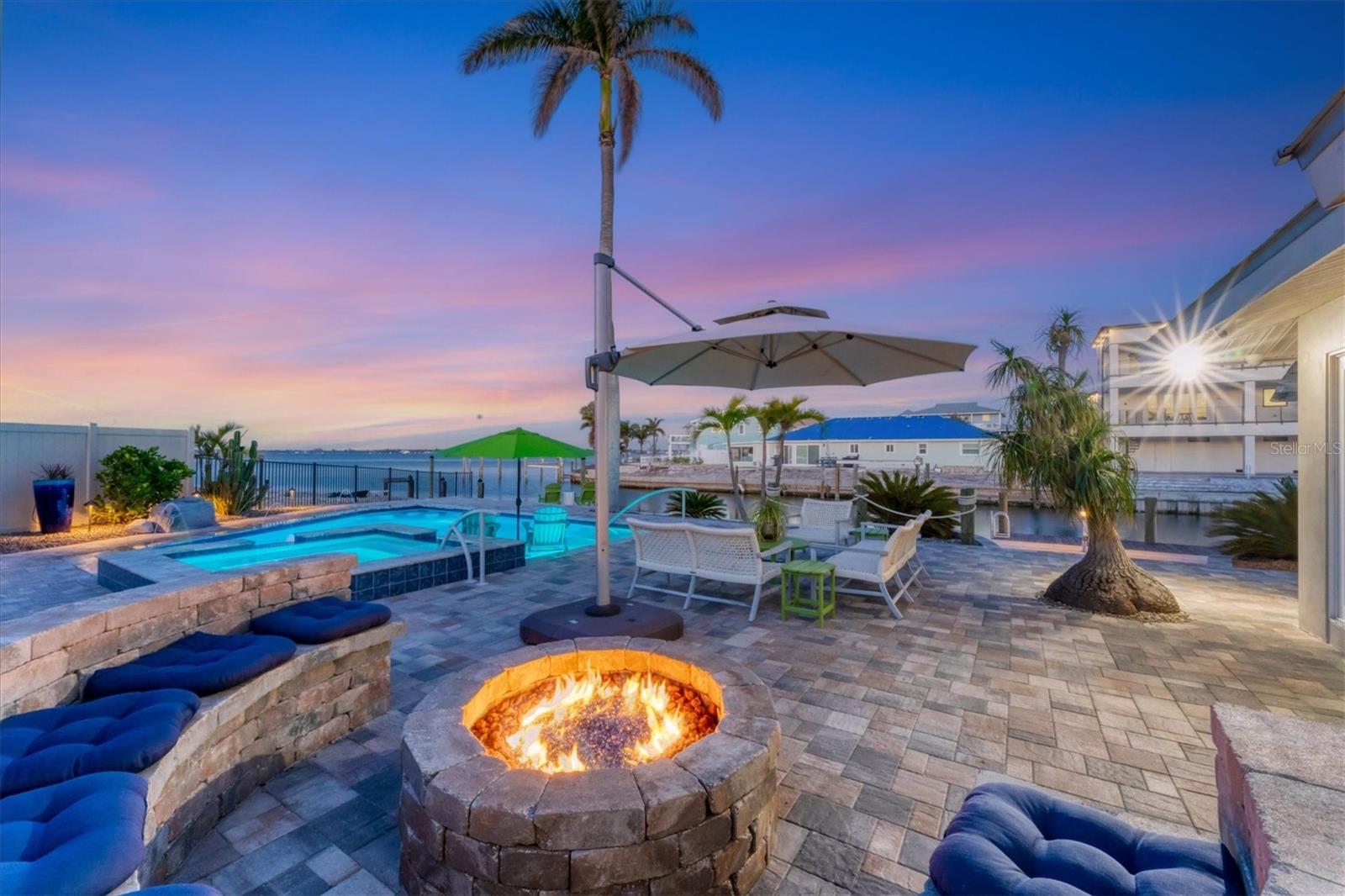 Looking for a resort lifestyle? Consider this stunning 2,900-square-foot bayfront property in the San Remo Shores community with breathtaking open-water views of Palma Sola Bay along with the ultimate boating and Florida lifestyle. Homes like this are rarely available, especially with this level of fit and finish. Upon entering, you’re greeted by an open-concept living space with expansive bay views from slider doors you’ll want wide open on the many glorious days. Additional large slider doors open to the lovely canal-front lanai where you can watch dolphins chasing their next meal. The gourmet kitchen is beautifully appointed with a Sub-Zero stainless refrigerator, two Bosch dishwashers, Monogram microwave, oven, warming drawer, induction cooktop and hood, wine refrigerator, solid stone countertops on two huge islands, along with custom cabinetry, seamlessly flowing into the spacious dining and living areas. Push a button and the TV lift drops from the ceiling. The large hidden pantry is a gourmet’s delight. Plantation shutters are on all windows. The home and pool suffered no flooding in the recent storms, according to the owner. Metal Roof new in 2021. Baths updated in 2024. Wake up and pinch yourself in the primary suite upstairs, offering big water views from the large picture window. It also has a cozy sitting area, en-suite bath and ample closet space. The two additional bedrooms are generously sized, and each also has an en-suite bath, offering comfort for family or guests. The resort-style pool and spa deck are the crown jewels built in 2023. Come home from the beach and rinse off in the outdoor shower, then relax in the fabulous patio area which provides wonderful space for dining, lounging, laughing by the built-in gas fire pit and soaking in the picturesque waterfront sunsets. Lush tropical landscaping with automatic irrigation and low-maintenance stone ground cover complements the picturesque setting. Watch as the ospreys seek their next meal while dolphins and manatees cruise by. This home is a boater’s dream, offering a large private dock, 20,000- and 7,000-pound boat lifts, deepwater access, and proximity to the Intercoastal Waterway and Gulf of Mexico. The smaller lift has a kayak launch platform near the convenient kayak racks. Ideal for those seeking a luxurious coastal lifestyle, this San Remo Shores gem is a rare find, blending elegance with the excitement of waterfront living and entertaining.