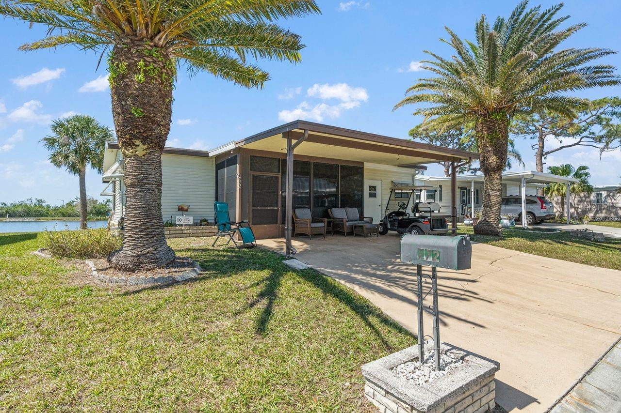 PRICE REDUCED by over $9K! Live the LAKEFRONT dream in this adorable 2-bedroom, 2-bath home in the desirable 55+ GULF ACCESS community of Harbor Cove. Imagine enjoying dinner or happy hour beverages from your 32-foot long LAKESIDE enclosed lanai watching breathtaking sunsets over the water! This room adds approx. 320 SF to the living space and wildlife viewing is a wonderful everyday occurrence here. This charming cottage style home features vaulted ceilings and attractive low-maintenance laminate flooring with both the living room and primary suite having direct lanai access and views. Tons of closet space in both bedrooms and the primary has an ensuite bathroom with walk in shower. Nice dining area adjacent to the kitchen and the small office nook has many possibilities. Updates include the kitchen range and microwave, newer roof (2023) and all windows replaced (2017). In front find a carport, covered enclosed porch and storage shed. Most furnishings are included. With HOA fees of only $150/month, including lawn mowing, a Membership Share and seawall maintenance, you'll have more time to indulge in the incredible amenities: two pools, a spa, tennis, pickleball, shuffleboard, bocce courts, billiards, fishing and a fitness center. The huge 2-story activities center overlooking the 90-slip marina hosts dances, parties, picnics, card games and more. You’ll have Gulf access via the Myakka River and can rent a boat slip for just $100 a year! Dining, shopping, medical services, parks and beaches are a short drive away. Don't miss out on this opportunity to live the resort lifestyle at an affordable price!