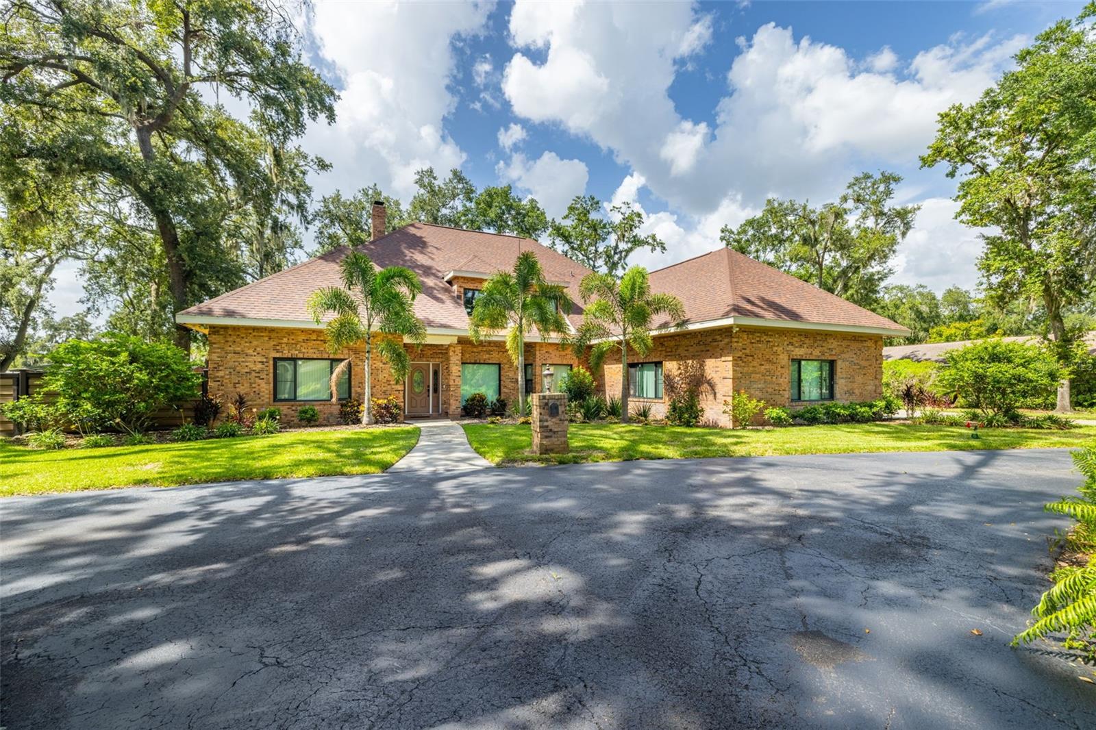 Tucked away at the end of a quiet dead-end street, this beautifully renovated custom pool home offers privacy, charm, and an impressive list of upgrades. Surrounded by mature, fully redone landscaping and a classic brick exterior, the curb appeal is unmatched. Recent updates include a new Trex front fence, 200 feet of new chain-link fencing, and a leaf guard gutter system. Step inside to discover a stunning, fully renovated interior completed over the past two years. The heart of the home is a show stopping chef’s kitchen featuring top-of-the-line Thermador appliances, including a dual-fuel gas/electric range, built-in bar fridge, Bosch dishwasher and Wi-Fi enabled smart features. The kitchen and dining area are also equipped with KASA-brand smart lighting, compatible with Alexa and Google. Durable waterproof laminate flooring flows throughout the home, complemented by freshly painted living spaces and all-LED lighting. Major mechanical and system updates include: Three new A/C units and handlers, Three hot water heaters (replaced June 2023), Main sewer line fully replaced (July 2023), whole-home water filtration system, fully paid off solar system and a 250-gallon propane tank powering the automatic Generac generator so no need to worry about losing power during one of our Florida storms. All windows were replaced with impact-rated models in April 2024. The garage doors, epoxy-coated garage floors (June 2023), and epoxy driveway (August 2024) are all brand new. A newly installed sprinkler system covers the front yard and along the backyard fence, ensuring the landscaping stays lush and well-maintained year-round. The spacious living room features a newly replaced fireplace insert and grand brick wood-burning fireplace, with multiple sets of French doors that lead to the expansive 35' x 17' screened in heated pool—perfect for entertaining. The pool enclosure has puncture-proof screens, and the pool surface was resurfaced in October 2024. Both the pool bath and a separate half bath have been recently renovated. All four bedrooms are generously sized with ample closet space. Two upstairs bedrooms are located off a large bonus room that includes a cedar closet for seasonal storage and a pool table with equipment included in the sale. The spacious office provides flexibility for working from home. Retreat to the primary suite and enjoy your private hot tub and sauna room, finished in premium clear no-knot cedar, creating a spa-like experience in the comfort of your home. The pool table and equipment are included with the purchase of this home. This home is truly one-of-a-kind and move-in ready with every major upgrade already completed. Photos simply don’t do it justice—schedule your private showing today to experience everything this incredible property has to offer.