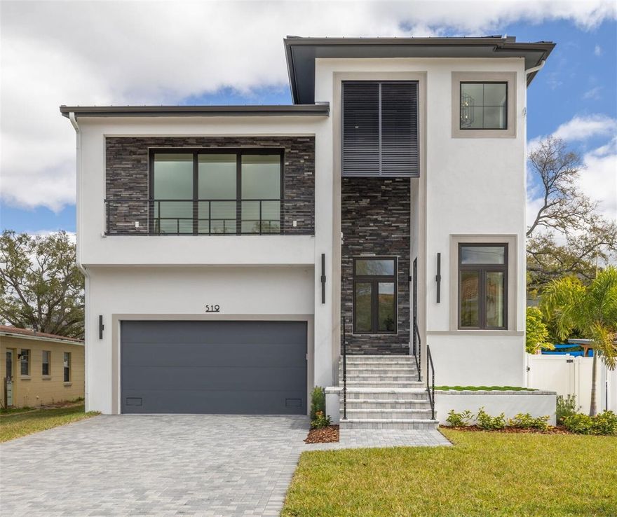 Thoughtfully crafted with a refined transitional coastal aesthetic, this newly completed luxury residence offers 3,828 square feet of beautifully curated living in the heart of Davis Islands. Designed for effortless entertaining and private retreat alike, the home blends architectural presence, outdoor living, and elevated finishes throughout.

Natural light pours through oversized casement windows, highlighting 12-foot ceilings and wide-plank white oak flooring that enhance the openness and airy feel of the first-floor layout. The open-concept great room flows seamlessly to the outdoor living areas, creating volume while maintaining warmth and livability. A private first-floor office with glass sliding doors, a convenient half bath, and a guest suite with en-suite bath provide flexibility and privacy for both daily life and visiting guests.

The gourmet kitchen pairs crisp white custom cabinetry with a seafoam-accented island, quartz countertops, and elegant gold hardware for a refined yet inviting design. The oversized island offers generous prep space, storage, and casual dining, making it the natural centerpiece of the home. A Thermador appliance suite includes a 48-inch gas range with griddle, dual 30-inch ovens, 48-inch French door refrigerator/freezer, stainless hood, under-counter microwave and complemented by a Bosch dishwasher. The adjacent dining area features a built-in dry bar with glass reflective backsplash, display shelving, under-counter storage, and wine and beverage refrigeration—perfect for entertaining.

Behind a shiplap-designed Murphy door, a private mid-level bonus retreat with balcony and half bath provides versatile space for a lounge, office, or guest overflow.

Upstairs, 10-foot ceilings frame a luxurious primary suite with two walk-in closets and a spa-inspired bath featuring a freestanding soaking tub, quartz vanity, and oversized walk-in shower with rain head and frameless glass enclosure. A separate dry bar with beverage refrigerator—pre-plumbed for a coffee maker—opens to a private balcony, creating a peaceful escape within the suite. Three additional bedrooms each include their own full bath with designer tile finishes.

Outdoor living is private and intentional. The fully screened covered lanai with stacked stone accent wall overlooks a courtyard-style backyard designed for relaxation and entertaining. A sun-shelf pool with water features creates a tranquil focal point, while the upper-level covered porch includes an outdoor kitchen with beverage refrigerator and is prewired for television.

Additional features include impact windows and doors, 12-foot elevation, standing seam metal roof, tankless gas water heater, and prewiring for a 26KW gas generator.

Located on picturesque Davis Islands, this home offers an unparalleled lifestyle in a vibrant, walkable community favored by professional athletes, executives, and families alike. The neighborhood is home to a wealth of amenities, including Marjory Park Marina, the Sandra Freedman Tennis Complex, the historic Roy Jenkins pool, and Peter O. Knight Airport. A short stroll brings you to the Davis Islands Village, where you’ll find a variety of restaurants and shops. With its prime location just minutes from Downtown Tampa, Water Street, Sparkman Wharf, and the Tampa Riverwalk, this home truly offers the best of both island living and urban convenience. Additionaly located in the A rates Gorrie, Wilson and Plant boundaries.