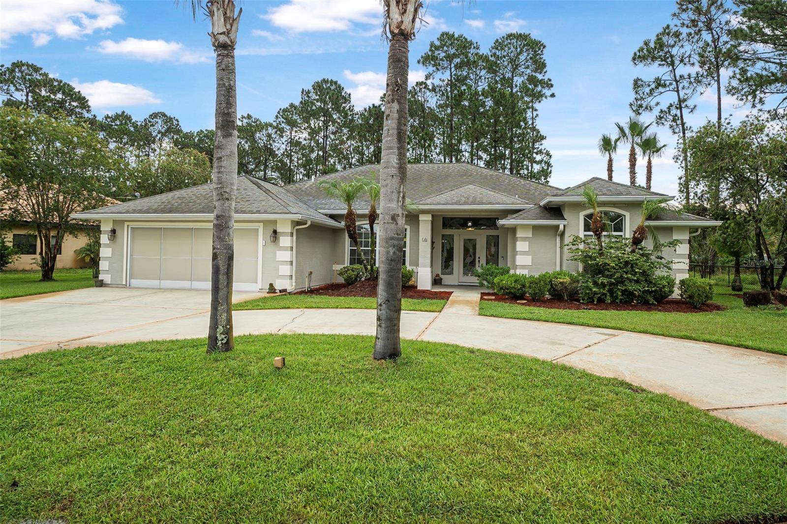 One or more photo(s) has been virtually staged. **Comprehensive Luxury Living in Palm Coast!**
Welcome to this exceptional Palm Coast home, where every detail has been thoughtfully designed for comfort, convenience, and modern living! A welcoming circular driveway offers the ultimate flexibility, allowing you to pull directly up to the front door or proceed to the oversized garage, which comes complete with a handy work station and ample storage cabinets. For all your outdoor tools, a small outside shed is conveniently located in the backyard. You'll rest easy knowing the property is equipped with hurricane shutters, a comprehensive burglar alarm system,(if you chose to activate) and the entire backyard is secured with a chain link fence.
Step inside through the stunning etched glass front door, showcasing a beautiful palm tree and egret design, and immediately be captivated by the open floor plan with impressive high ceilings – perfect for entertaining and daily living.
The heart of this home is its truly luxurious custom-built kitchen, a chef's dream! Boasting gleaming granite countertops and a seamless full granite backsplash, this space exudes elegance. Details like crown molding on both the top and bottom of the cabinetry, coupled with ambient warm under-cabinet lighting, elevate the design. Practicality meets luxury with a deep double sink, built-in trash compactor, and soft-close cabinets featuring convenient roll-out trays for effortless organization. Pots and pans find their perfect home in clever drawer-based cabinets. All superior appliances are less than two years old, ensuring modern efficiency. A large, beautifully trimmed pantry perfectly matches the kitchen's custom thought out design, offering abundant storage.
The expansive master suite offers a private retreat, featuring his and her walk-in closets providing abundant storage for your wardrobe. The luxurious master bathroom is designed for ultimate comfort, boasting his and her sinks set into elegant marble countertops. Enjoy a relaxing bath after a long day in a beautiful garden tub.
Outside, your private oasis awaits: a magnificent screened-in, inground saltwater pool featuring brand new equipment and an optional security fence for peace of mind. The convenience continues with direct access to the second bathroom from the pool deck, making splashes a breeze. Plus, maintaining your lush landscape is effortless thanks to a sprinkler system on a private well, and you'll always have hot water ready with a newer hot water heater offering instantaneous hot water.
This home offers the perfect blend of security, luxury, and outdoor enjoyment – a true Florida paradise!