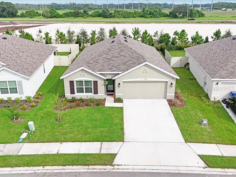 We are offering a $10,000 buyer credit that can be applied however you choose, whether toward a price reduction, closing costs, or a rate buy down on your mortgage. Welcome to this beautifully upgraded 4 bedroom, 2 bath home in the highly sought after Bella Lago community of Parrish, thoughtfully designed for both elegance and everyday comfort. The kitchen is a true showpiece with stainless steel appliances, granite countertops, and an oversized island ideal for gatherings. A walk in pantry provides exceptional storage, while designer pendant lighting adds a touch of sophistication. The open split floor plan flows seamlessly throughout, offering flexibility and privacy. The primary suite is a private retreat with a walk in closet and a spa like bath with double vanities. Three additional bedrooms provide generous space for a large family, guests, a nursery, or even a home office, with the fourth bedroom featuring modern built in cabinets that are both stylish and functional. Two hallway closets and an updated front door with glass insert add both function and natural light. Smart home features allow you to control the alarm, lights, thermostat, and garage door directly from your phone. Additional highlights include a Samsung washer and dryer, remote controlled ceiling fans, and an epoxy finished two car garage. The backyard is perfect for relaxing or entertaining, with fencing along the sides and mature hedges at the back that create privacy, complemented by upgraded photocell garage lights that enhance both safety and curb appeal. Hurricane rated double pane windows and shutters provide peace of mind, while thoughtful upgrades such as custom office built ins elevate the home’s design. Every detail has been carefully considered, making this residence truly move in ready. As a resident of Bella Lago you will also enjoy a wide array of amenities including a state of the art fitness center, luxury hotel inspired pool, playground, sidewalks for strolling, and irrigation with reclaimed water to keep the community beautifully maintained.