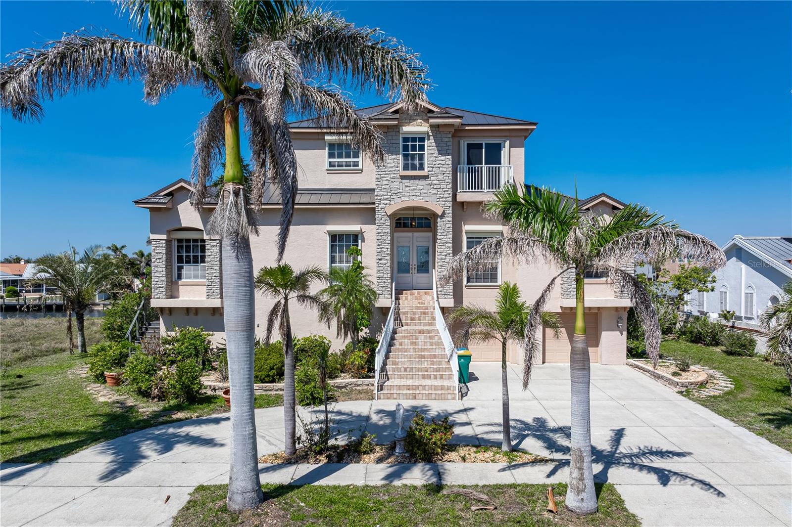 EXCEPTIONAL WATERFRONT HOME IN PORT CHARLOTTE W/NEARLY INSTANT ACCESS TO OPEN WATER! Looking for a spectacular waterfront residence w/***NEW METAL ROOF***, FIVE BEDROOMS (ALL OF THEM W/EN-SUITE BATHS), A PRIVATE DEN & OVER 4,100 SQFT of living space? Run, don't walk to this one-of-kind, two story home that was designed for entertaining. The first floor boasts a formal living room w/wet bar, formal dining room, home office plus a LARGE kitchen & spacious family room w/fireplace. The living room, family room & two guest rooms open to the balcony area that overlooks the pool. True chef's kitchen offers an abundance of cabinet & counter space w/a center island & prep area, stainless steel appliances (w/two dishwashers), plus an oversized walk-in pantry. The adjacent breakfast nook offers direct access to the balcony w/views of the pool & canal beyond. Three bedrooms are found on the main floor - each w/a large, walk-in closet & private en-suite bath. The master bedroom, laundry room & 5th bedroom are located on the second floor. The master suite features awesome views of Charlotte Harbor, a bump-out seating area & two unexpectedly large walk-in closets. The master bath has dual sinks atop a floating vanity w/stone counter plus a jetted garden tub & separate walk-in closet. The private WC has two linen closets. There is no shortage of storage space here! The 5th bedroom has (of course) an en-suite bath PLUS a balcony overlooking the canal view behind the home. The two-story pool cage encompasses the ground floor level area plus the balcony off the main floor. From the ground level, you'll enjoy the in-ground pool that is surrounded by a brick paver deck plus a summer kitchen, half bath & ample covered space that is perfect for a ping pong or foosball table, dedicated workshop area. The space has been used to host large parties w/catered food & tables filling the space w/laughter & conversation. Picture hosting memorable family gatherings here! An oversized, composite dock is located just steps from the back door. Keep your boat in your backyard & start enjoying some of the best fishing & boating in SW Florida immediately! You could swim to open water from the dock! Best of both worlds w/harbor views available from the front of the home & protected canal/dock for your boat at the back of the home. Other amenities include two A/C systems, hurricane protection, large coat/shoe closet at the foyer & an oversized two-car garage w/split doors. For the gardening enthusiasts, this house has an abundance of Mango, Fig, Chikoo, Lychee, Sugar Apple trees and more! Make an appointment today, you won't be disappointed.