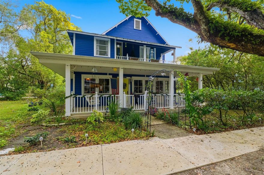 Stepping onto the wraparound porch shaded by mature trees, you’re immediately welcomed by the peaceful, park-like atmosphere that surrounds this charming two-story home set on a generous 0.41-acre lot. The enclosed sunroom invites you in with its wood paneling, warm natural light, and views of the landscaped front yard, guiding you into a foyer lined with rich wood flooring that leads toward the heart of the home. To the right, the living room feels instantly comforting with tall windows framing the greenery outdoors and a gas fireplace that anchors the space, flowing seamlessly into a bright dining room accented by elegant trim and another fireplace that adds charm and continuity. Moving deeper into the home, the first-floor bedroom offers quiet flexibility, while the nearby bathroom showcases classic tilework and a step-in shower. Toward the rear, the family room opens up with high ceilings, smooth patterned flooring, and an easy connection to the spacious kitchen, where generous cabinetry, wide counters, a central prep island, and a bar area create the ideal setting for daily living and memorable gatherings. Upstairs, a soft-toned hallway leads to multiple bedrooms, including a welcoming primary suite filled with natural light from twin windows and direct access to an adjoining area that connects to a covered balcony. Another second-floor bedroom features wood flooring and a gas fireplace, while the remaining bedroom offers a spacious layout with carpet and its own balcony access, perfect for enjoying fresh air and quiet views. Outside, a covered porch overlooks the rear patio, which connects to the laundry area and provides a pathway to the in-ground pool privately enclosed by fencing, while the expansive backyard includes concrete sections and storage sheds, offering both function and room to enjoy the outdoors. Living here places you close to notable local attractions such as Tom Varn Park, known for its sports fields, playground, and shaded walking trails; Hernando Park, which hosts community events, green space, and a splash pad; and the historic Brooksville Downtown District, where charming shops, cafés, and local landmarks create a vibrant place to explore.
