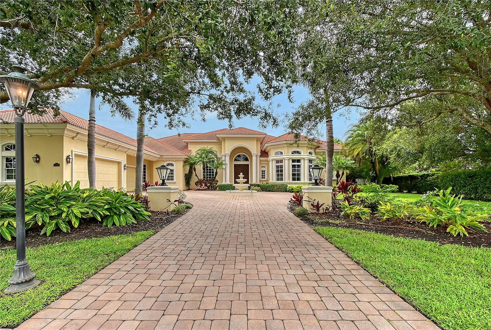 Welcome to The Founders Club, Sarasota’s premier gated golf community, where timeless design meets modern luxury. This stunning John Cannon–built estate, situated on nearly an acre, offers over 6,300 square feet of living space all on one floor with 4 bedrooms, 4.5 bathrooms, and a thoughtful single-level layout designed for both entertaining and everyday living.
From the moment you arrive, the home’s circular drive, lush landscaping, and elegant architectural details set the stage for what lies inside. Step through grand double doors and into open, light-filled living spaces where soaring ceilings, crown molding, and refined finishes create a warm and inviting atmosphere.
The heart of the home is the chef’s kitchen, featuring solid wood cabinetry, granite counters, built-in shelving, and a spacious open layout that flows seamlessly into the family room and casual dining area. A separate formal dining space and living room provide options for intimate gatherings or larger celebrations.
The private primary suite is a true retreat with dual walk-in closets, a spa-like bath boasting a whirlpool tub, multiple shower heads, and stone counters. Three additional bedrooms each feature en suite baths, offering privacy and comfort for family and guests. A dedicated office, media room, and bonus/game room with wet bar provide flexible space for work, play, or relaxation.
Outdoor living is equally impressive. Step out to a covered lanai with an outdoor kitchen and grilling area, overlooking a sparkling pool and spa. Surrounded by a private courtyard, this backyard oasis is perfect for year-round enjoyment.
Additional highlights include a 4-car side-entry garage, gas fireplace, French doors, and energy-efficient features with FGBC Green Certification and new interior paint work.
Residents of The Founders Club enjoy a private, guard-gated lifestyle with optional golf and country club membership, just minutes from downtown Sarasota, world-class beaches, and A-rated schools.
This estate is a rare opportunity to experience luxury living in one of Sarasota’s most exclusive communities.