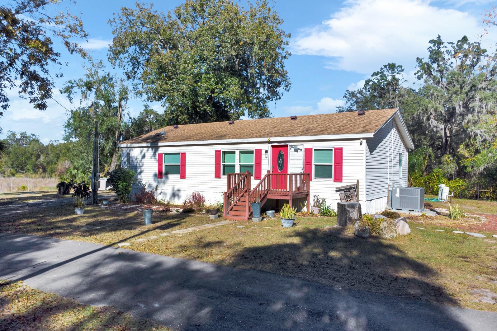 Experience the perfect blend of comfort, space, and freedom with this beautiful 3-bedroom, 2-bath mobile home nestled on 2.31 acres in Davenport, Polk County — and NO HOA! Enjoy the open floor plan featuring stylish wood laminate flooring throughout, a spacious kitchen with granite countertops, and plenty of natural light that creates a warm and welcoming atmosphere. The split floor plan offers privacy, with the primary suite conveniently located away from the guest bedrooms. The master bathroom is designed for relaxation, featuring a soothing garden tub and a walk-in shower. Step outside and embrace the Florida lifestyle — perfect for family gatherings, picnics, or cozy evenings around the firepit. With a detached carport and a detached 3-car garage, there’s ample space for all your vehicles, storage, or workshop needs. Plus, bring all your boats, RVs, campers, and pets — there are no restrictions! Enjoy the peaceful surroundings, calming views, and the space to make this property truly your own. This is your chance to live the life you’ve always wanted — schedule your private showing today!