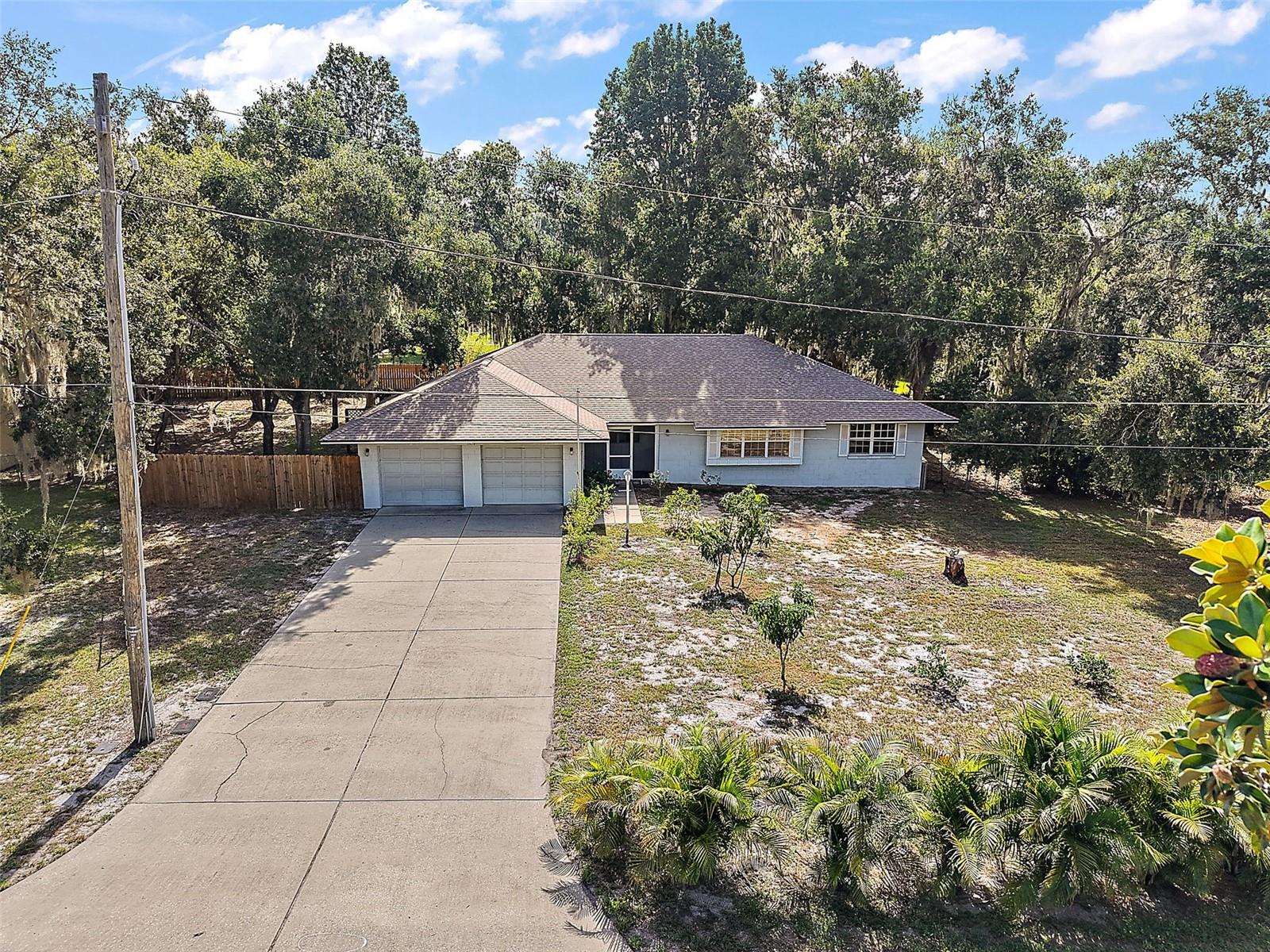 Welcome to your peaceful retreat in the charming and well-established Dora Manor community - where Old Florida charm meets modern-day potential. Nestled beneath majestic oak trees draped in Spanish moss, this neighborhood is just steps from the shimmering shores of Lake Dora. Take a leisurely stroll to the community dock to enjoy a breathtaking sunset or spend a quiet afternoon fishing in the lake’s tranquil waters. Set on an oversized .58-acre lot, this attractive 3-bedroom home offers solid bones and an abundance of potential. With a little TLC and some cosmetic updates, it could become your dream home in one of Mt. Dora’s most desirable locations—just minutes from historic downtown. Significant updates have already been made: a new roof (2023), new A/C (2024), and a new water heater (2018). A long, oversized driveway and 2-car garage ensure ample parking for guests. At the same time, the tropical front yard—complete with palm trees and avocado, mango, and lemon trees—sets a relaxed Florida vibe from the moment you arrive. Step through the screened front porch into a light-filled interior featuring a split-bedroom floor plan and multiple living spaces, perfect for today’s flexible lifestyles. Entertain with ease—whether it’s hosting family holidays or casual gatherings with friends. The front living room boasts large windows and built-in shelving, flowing seamlessly into a spacious dining area and then into a generously sized family room with panoramic windows, more built-ins, and access to the screened lanai and backyard. The kitchen is full of charm and functionality, with ample cabinet and counter space, a French-door refrigerator, a double-door pantry, a breakfast bar, and a cheerful bay window dinette—perfect for casual meals. The primary bedroom features wood-look laminate flooring, an abundance of natural light, a spacious closet, and convenient access to a full hall bathroom with a tub/shower. Bedrooms 2 and 3 are located on the opposite side of the home and share a second full bathroom. The 2-car garage includes a separate air-conditioned laundry room for added convenience. Out back, the spacious screened lanai is ideal for lounging or dining, and the fully fenced yard offers both privacy and space for pets, play, or gardening. There’s even a storage shed for your tools and outdoor gear. This property is a rare find—offering a peaceful setting, a generous lot, and an unbeatable location just 1.8 miles from historic downtown Mt. Dora, where you’ll find a full-service marina, quaint boutiques, cozy cafes, fine dining, art galleries, festivals, and so much more. With vision and a little effort, this home can become a true showstopper. See the potential—and fall in love with the charm, space, and lifestyle this Mt. Dora gem has to offer.