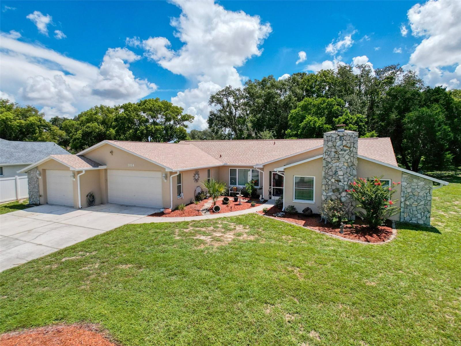 Welcome to your dream home at 2124 Little Peach Court in beautiful Spring Hill! This stunning pool home sits on over half an acre in a peaceful cul-de-sac with no HOA, offering the perfect blend of privacy and convenience. BRAND NEW ROOF with 50-year shingles, new gutters, and fresh exterior paint. The interior is just as impressive, with 2021 energy-efficient windows, ceramic tile, and brand-new laminate flooring throughout—no carpet here! Enjoy low electric bills thanks to a radiant barrier and extra insulation. The warm and inviting living and dining areas are separated by a charming wood beam, adding character to the open layout. A spacious 18x17 family room features another rustic wood beam and a gorgeous stone wood-burning fireplace (easily converts to gas), making it the perfect spot to relax or even set up a game room. The newly renovated kitchen is a chef's delight with granite countertops, tile backsplash, recessed lighting, newer stainless appliances, a breakfast bar, and plenty of brand-new cabinetry, including a pantry with pull-out drawers and a cozy breakfast nook. You will love the oversized bedrooms with lots of closet space, an elegant guest bath with tile tub/shower combo and a new vanity, and a spacious master bath with a walk-in shower and generous vanity space. The indoor laundry room offers additional cabinetry and leads to a 2-car garage plus a 35-ft boat garage, complete with an RV hookup and extended driveway for extra parking. Out back, enjoy Florida living at its finest on the huge 30-foot covered lanai, overlooking the newly screened sparkling pool and private backyard—ideal for entertaining year-round. Centrally located in one of the most desirable areas of Spring Hill, you're close to beaches, shopping, restaurants, and medical facilities. Prepare to be WOWED!