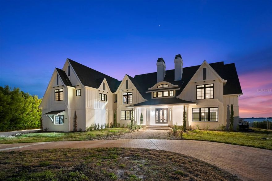 Welcome to River Oak Estate. Over an acre of land located at the mouth of the Manatee River with direct access to the Gulf of Mexico and Tampa Bay. This completely updated home offers an inspiring blend of Coastal Modern Elegance and Country Manor Ease, pleasing the most discerning designer’s palate. Salted breezes sweep down the 300’ drive under a canopy of oaks to find this stately home at water’s edge. The traditional Tudor style is complemented with gracefully sloping roof lines over a creamy stucco with board on batten detail. A lofty eyebrow arch floats above the covered porch, welcoming guests to this private paradise! Once inside, you are drawn to the water, tempted to run your hands along cool crafted ironwork in the grand foyer. Beneath coffered ceilings, sunlight streams in through sky high windows, casting playful shadows across driftwood-colored floors. Through a wall of sliding doors, the harlequin patterned travertine teases toward the edge of the infinity pool and spa. Imagine the changing color of the sky while gas fire bowls flicker along the lanai and the Skyway Bridge comes into view. Prepare your signature dish in the chef’s kitchen, complete with a six-burner gas range, pot filler, three wall ovens, French door refrigerator freezer and a walk-in butler’s pantry, all centered around a large quartz island. Custom cabinetry surrounds the space with creative storage for your culinary tools. Also on the main level is the grand salon with a wall of built-in shelving, window seats, media alcove, and massive wood burning fireplace which serves as a centerpiece between the sprawling lawn and sea. The cozy library is a great gameday getaway with custom cabinetry, wet bar, wine and beverage refrigeration and sliding wall to conceal the big screen TV.  Atop the sweeping staircase, you will find two guest suites, both opening to the covered balcony, and a luxurious primary suite. This spectacular owners’ retreat has two large rooms opening to the balcony, two full baths, a custom walk-in closet and a modern gas fireplace. The first of the owners’ baths has a glass enclosed shower with elegant black marble and gold accents, a single vanity and water closet. The second bath is finished in creamy travertine with two vanities, water closet, a large walk-in shower with multiple shower heads and a lounge area. Add a dressing room, soaking tub or sauna for the ultimate at-home spa! Over 6,000 square feet of living area includes the Cabana or Captain’s Quarters. This charming brick guest house has a private entrance, brick floors and pecky cypress walls, galley kitchen, and full bath with shower.  The Cabana opens to the covered lanai and pool with sliding doors and stairs leading to the waterfront.  With around 160’ of seawall, the private dock stretches into the river with fishing pier and covered 14,000 boat lift. Moor your larger vessel in this sailboat water with Gulf and Bay access. Take your paddle board and a picnic over to Desoto National Park. This tiny National Treasure has pristine beaches, shaded boardwalks and shell paths to the Gulf of Mexico. For your land vessels, there are two attached garages for four vehicles, each climate controlled with mini-split AC systems. These oversized garages have plenty of space for workshop and additional storage. This is a magical setting, between Downtown Bradenton and Anna Maria Island. This home has hosted generations of tree climbing, boating, fishing, shell seeking and day dreaming.