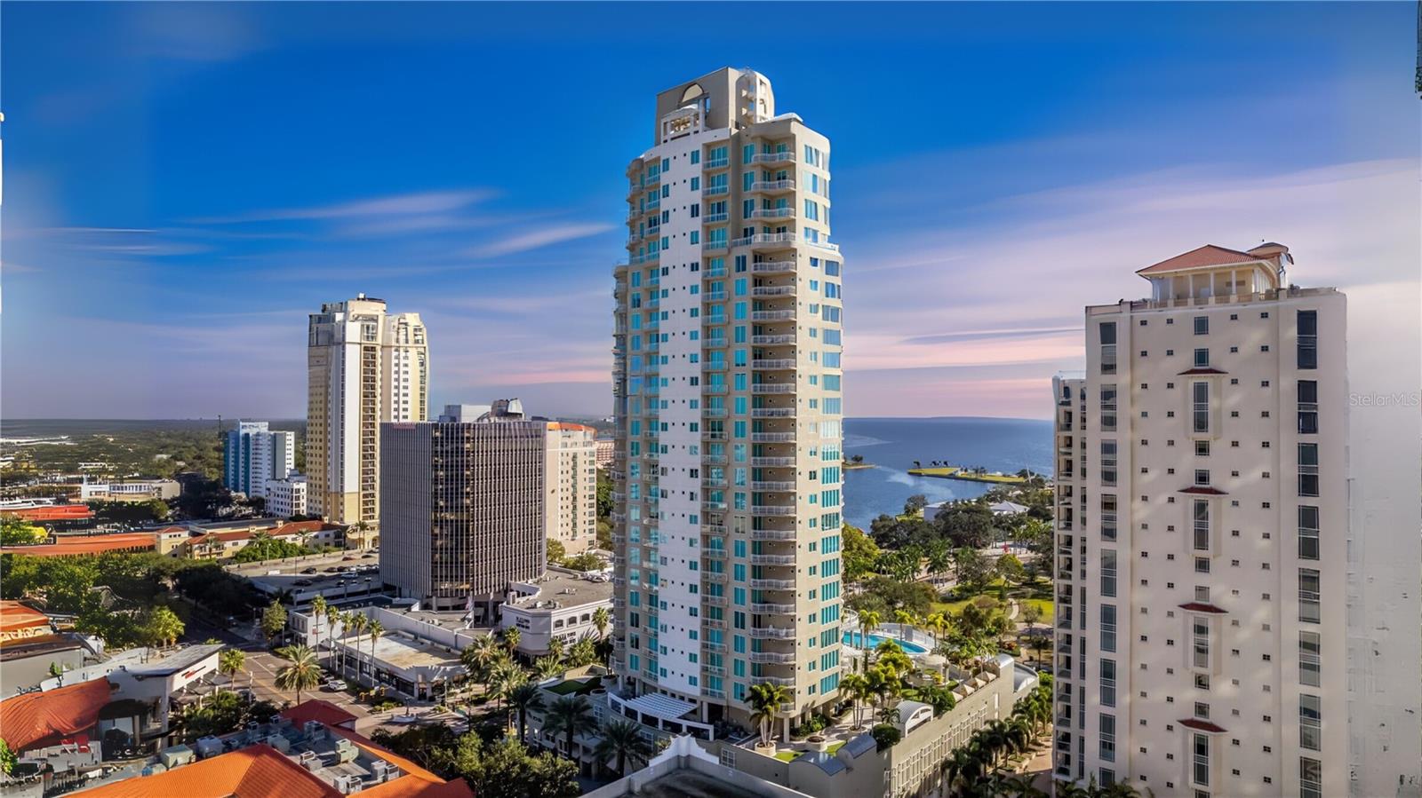 Ovation, located in the heart of St. Petersburg, offers an unparalleled lifestyle of luxury, privacy, and convenience. Enter through an impressive entrance where double elevator doors open directly into a sprawling 3,660 sq. ft. residence. With full-length windows, 10-foot ceilings, and wraparound terraces, this 18th-floor home is bathed in natural light and fresh bay breezes, providing breathtaking views from sunrise to sunset. The highly sought-after unit features open living spaces that showcase stunning views of the waterfront to the south and east, where sailing ships and private yachts grace the marina alongside the glide of private planes overhead.
Originally designed as the model home, this luxurious residence boasts state-of-the-art technology and designer finishes, including Lutron electric shades, Allikriste cabinetry, Bang & Olufsen home theatre wiring, and distinct decorative lighting throughout. Additional highlights include elegant porcelain tile and hardwood flooring, smooth walls, double-tray ceilings, and soft cove lighting.
Indulge yourself and your guests in the expansive gourmet kitchen featuring custom cabinetry, soft-touch drawers, roll-outs, top-of-the-line Wolf and Sub-Zero appliances, quartz countertops, and a generous island with abundant storage. Retreat to the master suite, complete with a private terrace, circular walk-in closet, and a lavish en-suite bathroom. Each of the two guest bedrooms also features its own balcony and en-suite full bathroom, ensuring comfort for friends and family.