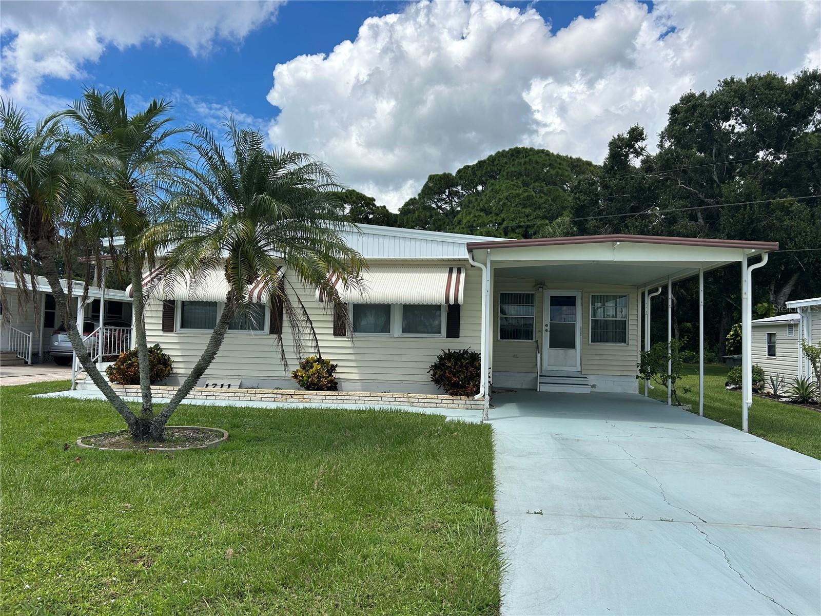 Awesome location - In dog allowed area - Beautiful backyard view of wooded area. Brand new roof on this home installed December 2024! Great open floor plan, roomy Liv Rm & Din Rm flooring is newer - windows have been replaced, well cared for, large lania, fenced back yard, working kitchen - so much to like about this property. Everything stays except personel items & small table in Living Rm. Golf cart does not stay. Tri-Par Estates is a 55+ community in which you own your home and the land. Park fee of $1,648.00 a year is part of the property taxes paid once a year, includes Frontier internet, cable also trash. There is a large pool, mini golf, laundry facilities, fitness room, clubhouse, and many activities to enjoy. Just minutes to the airport and with many other necessities nearby like hospitals, shopping, restaurants and more. Airplanes & jets do fly over Tri Par Estates. Certainly a property to consider