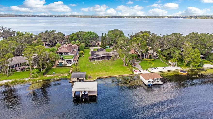 Welcome to Second Avenue…a quiet peninsula in the heart of Old Windermere. This ¾ acre waterfront property boasts 125 feet of sandy shoreline, concrete seawall and sweeping views of Wauseon Bay. Ultra two story boathouse includes sundeck, boat lift and double jetski lifts. There is a 600 sf building lakeside with potential to become your cabana, office, game room or whatever you can imagine.  This structure is grandfathered and could not be built today! Existing single story, mid century 3,000 sf home has not been lived in since 2017.  Restore, renovate or build new.  Property has access to natural gas and Orange County water.
Windermere affords a small town lifestyle yet close to major roadways, fine dining, renowned golf and area attractions.  Residents enjoy the security of having their own respected police department.  Walking distance to local restaurants, shops, brewery and seasonal events. Golf carts welcome and no HOA dues or restrictions.
The Butler Chain is designated as one of Florida’s Outstanding Waterways.  There are 11 pristine, interconnecting lakes sure to please all water enthusiasts.