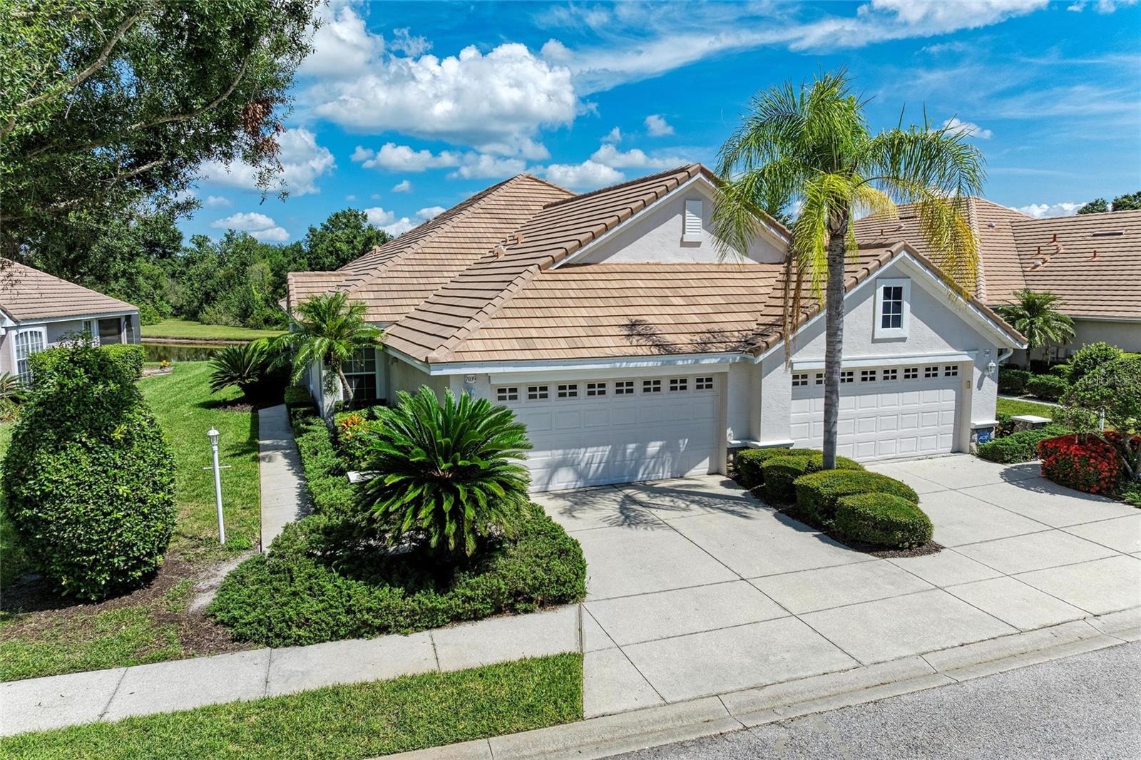 First time ever on the market, this one-owner residence offers exceptional care and is a beautifully maintained villa in the sought-after Weston neighborhood nestled behind the gates of the Lakewood Ranch Golf & Country Club. A NEW TILE ROOF recently installed in February 2025, is an incredible upgrade offering lasting value and peace of mind. This perfectly positioned 2-bedroom, 2-bathroom residence offers a den/office with a closet that can be used as a third bedroom and is ideally positioned with a tranquil water lot and preserve views. Here you will find an open and airy floor plan with high ceilings, freshly painted interiors, tile flooring throughout the main living spaces, and newer laminate flooring in both bedrooms. The spacious kitchen offers a granite breakfast bar and timeless laminate countertops, generous cabinet space, and a light-filled dining area separate from the expansive living room—perfect for everyday living and entertaining. The primary suite features tranquil lake views, a large closet, dual vanities, and an oversized shower. The “L” shaped extended screened-in lanai offers a peaceful outdoor retreat to enjoy the natural beauty of the lake and preserve. Additional features include the attached two-car garage, a laundry room with washer and dryer, ceiling fans throughout, and a terrific advantage of being an end unit is all the natural light flowing in from all windows and sliders. Residents of Weston enjoy a dedicated heated community pool and spa, along with cable/internet, exterior lawn and irrigation maintenance, all within the lush and manicured setting of Lakewood Ranch Country Club. Optional and convenient membership of the Country Club provides access to 4-championship golf courses, elegant clubhouses, a fully equipped athletic center with lap pools and fitness facilities, and numerous tennis and pickleball courts—with no wait list! Located just minutes from all the activities at Waterside Place and Lakewood Ranch Main Street, the Sarasota Polo Club, UTC shopping and dining, SRQ Airport, and the award-winning Gulf Coast beaches. Hurry, this maintenance free home offering the ultimate in Florida lifestyle living, won’t last long!