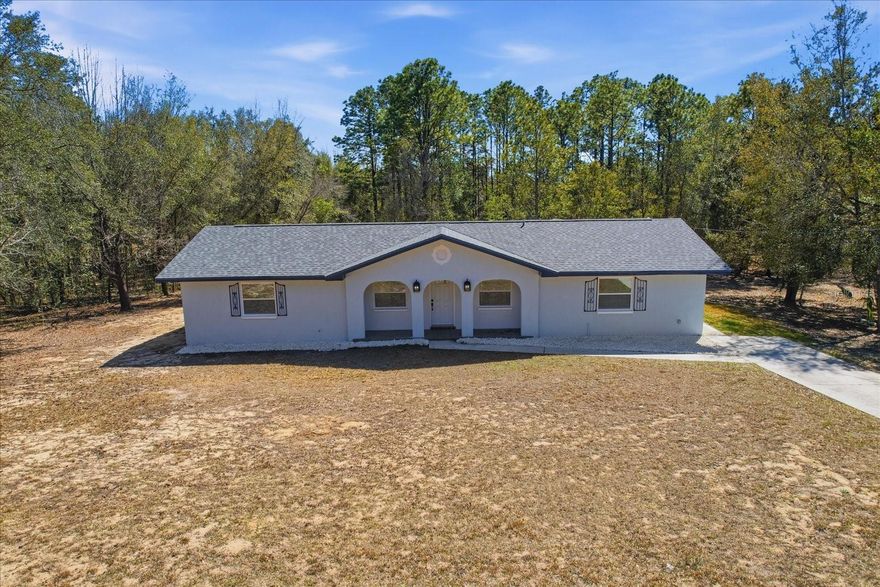 Situated on 1.36 acres, this updated 3/2 home offers privacy and functionality with a split-bedroom layout and open living spaces. No HOA. Kitchen features granite countertops and a pass-through for effortless entertaining. Tri-fold sliding doors open to a screened patio, creating a seamless indoor-outdoor living experience. Recent upgrades include a new roof, HVAC, and water heater. Surrounded by mature trees with no HOA and conveniently located near medical, dining, golf, and outdoor recreation.