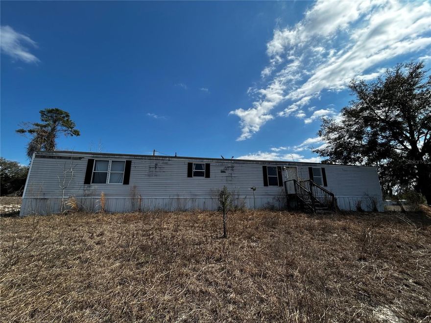 5 ACRES WITH ELECTRIC, WELL, SEPTIC AND FULLY FENCED in TRENTON, FL! Welcome to Gilchrist County - THIS is what you're looking for! FIVE fully fenced acres on a corner lot, with access to Christmas Lake and Dinner Pond. Electric, well, and septic are fully connected and waiting for you to put a manufactured home or build on this lot! There is NO HOA, but there are minimal deed restrictions. Horses and cows are allowed. Not only do you have lakes in your neighborhood, but just a short drive away are the Springs and the Suwannee River! Enjoy Hart Springs and Otter Springs. You're also a short drive to Newberry, which has Publix and other shopping and dining. Trenton also has a lot to offer, come explore the area and see all that there is for you to enjoy! This property currently has a manufactured home on it, but the value is attributed to the land and the utilities as the home is a fixer upper and needs TLC. Sold AS-IS. Come take a look, this is what everyone is searching for!! Just a little labor of love is needed to spruce up the yard and you can have your garden, an area for your horse(s) and cow(s), and whatever else you desire!