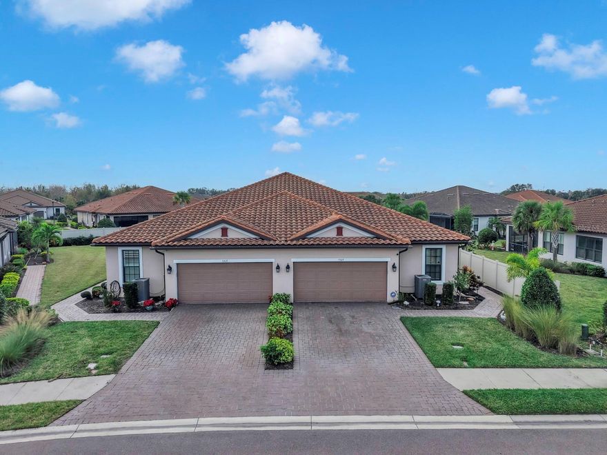 You won’t want to miss this beautifully upgraded Sandpiper Villa in Esplanade at Artisan Lakes, where thoughtful design, elegant finishes, and effortless Florida living come together seamlessly. Priced to sell, this 2-bedroom plus flex room villa offers a desirable split floor plan that provides both privacy and functionality. The versatile flex room is ideal for a home office, den, or a comfortable third sleeping space for visiting guests—making the home perfect for a seasonal getaway or a full-time residence. Custom built-ins in both bedrooms add style and smart storage, while tray ceilings with crown molding and 8’ doors throughout enhance the open, airy feel. A leaded-glass front door creates a warm and welcoming first impression. At the heart of the home, the open kitchen flows naturally into the living area—perfect for everyday living and entertaining alike. A separate dining space offers a more formal setting, while the expansive quartz countertop invites casual meals, conversation, and gatherings. The kitchen is beautifully appointed with stainless steel appliances, a gas cooktop, an upgraded large sink, and thoughtful finishes throughout. Smart lighting and dimmer switches allow you to easily set the mood, whether hosting guests or enjoying a quiet evening at home. Both bedrooms feature private en-suite bathrooms, offering comfort and convenience for owners and guests. The primary suite is a relaxing retreat with a walk-in shower featuring upgraded tile and a frameless glass enclosure. The second bedroom, tucked privately at the back of the home, includes its own en-suite with a large soaking tub—ideal for unwinding. A conveniently located half bath is perfect for visitors, and the adjacent laundry room offers built-in cabinetry and a sink for added functionality. Seamless indoor-outdoor living awaits as triple sliding glass doors open from the living area to the lanai, where you can relax or entertain while enjoying a larger-than-average villa lot with a private, landscaped backyard. A paver walkway with hard-wired lighting extends along the side of the home to the lanai, adding both elegance and easy access—perfect for embracing the Florida lifestyle. Additional highlights include a garage with epoxy flooring and built-in shelving, a tankless water heater, and gutters for added peace of mind. This maintenance-free villa allows you to truly enjoy resort-style living, with the HOA covering cable, internet, roof, and exterior painting—so you can spend more time enjoying your home and less time on upkeep. Esplanade at Artisan Lakes offers resort-style amenities, including two clubhouses with beautifully designed social and activity spaces. Residents enjoy two resort-style pools, a resistance pool, two spas, a state-of-the-art fitness center, movement studio, and outdoor recreation such as tennis, pickleball, bocce ball, and cornhole. Additional highlights include a fire pit, multiple lounging areas, both small and large dog parks, and a playground. A full-time lifestyle manager curates events, clubs, and activities, creating a vibrant community atmosphere. Conveniently located near I-75 and I-275, this home provides easy access to Tampa, St. Petersburg, Bradenton, Sarasota, airports, dining, shopping, golf, and the award-winning Gulf Coast beaches. Beautifully maintained, thoughtfully upgraded, and located in one of the area’s most desirable maintenance-free communities—this home is truly a must-see! *Attached video and 3D tour*
