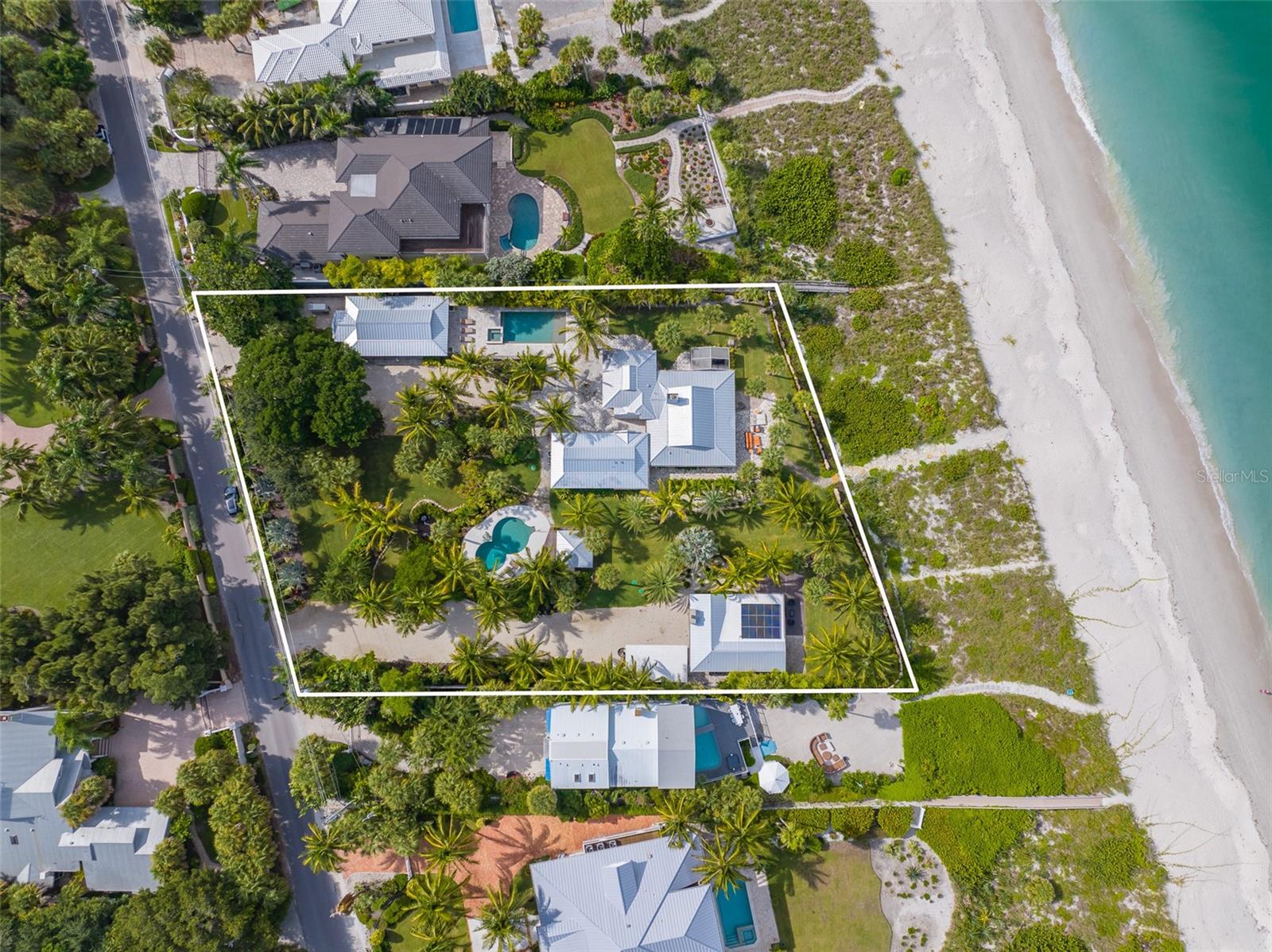 Under contract-accepting backup offers. DO NOT CONTACT SELLER. TEMPORARILY OFF MARKET. Discover your very own "Shangri-la", on one of the most desirable beaches along the West Coast of Florida. Casey Key is where this private beachfront estate awaits your arrival. A once-in-a-lifetime opportunity to purchase just shy of 2 acres and over 200 lineal feet of direct gulf coast frontage. This exclusive paradise comprises two beautifully maintained residences. The main house is a 4 bedroom/4 bathroom home that was completely renovated in recent years from top to bottom while maintaining its original island cottage charm. Walk across the luxurious grounds to the remodeled guest beach house, a two-bedroom coastal charmer. Both beach houses' have fantastic ocean views from rooms throughout, with interiors that ooze a relaxed island vibe. The look and feel is achieved through the use of soft colors and high-performance materials designed to be sun and mildew-resistant; but, the absolute best is yet to come... as the land and grounds in and of themselves make this the preeminent property on Casey Key. A just-completed expansive renovation to the property landscaping in 2022, the owner created a picturesque lush botanical oasis with landscape designs that look straight off the cover of a magazine. As you walk the grounds covered in Celebration Bermuda sod, you will notice that the lush tropical retreat reminds you of a 5-star resort. Outdoor elements to this property include two saltwater pools and multiple outdoor living areas, including but not limited to a Gazebo, a pavilion, a pergola, three car garage, and outdoor storage shed. This is all infused with the soothing sounds and beauty of the emerald green Gulf of Mexico, where large pods of dolphins are frequently seen. And nothing defines happiness more than relaxing from your hammocks set between the beautiful oceanside palms or enjoying one of the most sought-after sunset views in the world. See this one-of-a-kind property in person and prepare to be amazed.