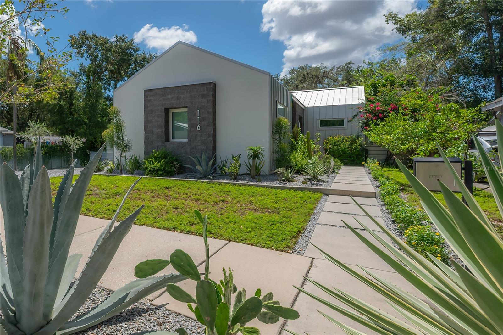 A unique blend of modern elegance and thoughtful design awaits at this Tampa Heights oasis. Located in the heart of Tampa, this home is bright and airy with soaring 10–13ft ceilings and meticulous finishes throughout, this one-of-a-kind property offers a main residence, fully appointed guesthouse/ADU, and oversized two-car garage with alley access. The 2-bedroom, 2-bath main home spans 1,250sqft and is filled with upscale details, from waterproof luxury vinyl plank flooring to an oversized kitchen island and custom built-ins. At its heart, the chef’s kitchen impresses with a dramatic 12ft island, natural gas range with split ovens, stainless hood vent, and sleek modern cabinetry—an entertainer’s dream. The primary suite showcases built-in wardrobes and a spa-inspired bath with dual vanities and an oversized walk-in shower, while the secondary suite features a walk-in closet with custom built-ins and a luxurious en suite with a 7ft soaking tub. Expansive 10ft sliders open to a private backyard retreat with an artist-painted mural, ambient lighting, dual koi ponds, and outdoor dining and lounge areas set on easy-care turf. The fully furnished 150sqft guesthouse/ADU is equally refined with a Murphy bed, sofa, kitchenette, full bath, private entry and parking, plus a patio with 4-person spa/hot tub—ideal for guests or rental income. The oversized 2 car garage offers storage, a workbench, EV charger, and additional parking. This turnkey property is truly unlike anything else in the neighborhood, combining modern sophistication, livable comfort, and endless flexibility—all just minutes from Armature Works, The Riverwalk, Downtown, Hyde Park Village, Water Street, Raymond James Stadium, Benchmark International Arena, Bayshore Blvd., and more.