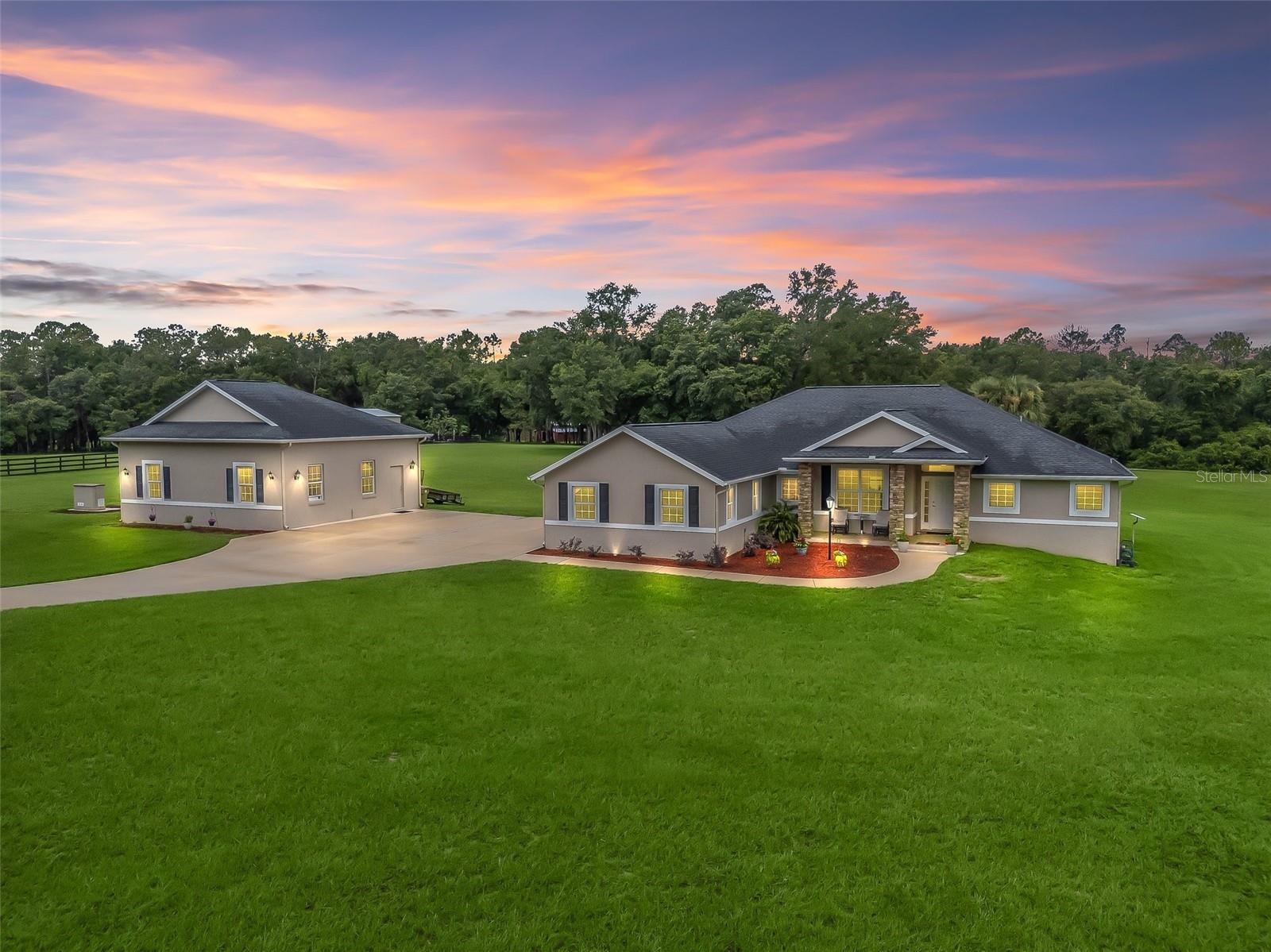 Custom-Built Home on 5+ Acres in Gated Equestrian Community of Saddle Ridge!
Welcome to this beautifully crafted custom home nestled on over 5 acres in an exclusive gated equestrian community. This spacious property offers the perfect blend of luxury, functionality, and serene country living. The property offers the perfect combination of cleared, established grassy fields and mature trees!
The home features 4 bedrooms and 2 bathrooms, with a thoughtfully designed floor plan. A long, elegant driveway leads you to the residence, where you’ll be greeted by immaculate landscaping, stacked stone-accented columns, and a covered front porch with tile flooring, a ceiling fan, and a cozy sitting area—perfect for relaxing evenings.
Inside, enjoy luxury vinyl and tile flooring throughout, granite countertops, and a chef’s kitchen complete with a breakfast bar with pendant lighting, stainless steel appliances, eat-in nook, and a formal dining room or bonus sitting area.
The great room boasts soaring ceilings, a 65” mounted TV, and a sleek electric fireplace—ideal for entertaining or relaxing. The master en-suite offers spa-like comfort with a Roman walk-in tiled shower, soaking tub, his and her vanities, his and her walk-in closets, and a private water closet.
Three additional bedrooms and a full guest bathroom with a tub/shower combo and glass sliding doors offer plenty of space for family or guests.
The climate-controlled Florida room with luxury vinyl flooring overlooks the expansive acreage and opens onto a concrete patio—ideal for outdoor gatherings. A charming enclosed gazebo completes the inviting backyard space.
For the hobbyist or car enthusiast, the property includes both a 3-car attached garage and a 30x30 detached garage/workshop with a storage cabinet, an electric door opener and 100-amp electrical service.
Additional features include - Smart Home technology with programmable light switches and occupancy sensors in the laundry, garage, and shed; and a Wireless Dog fence System covering the entire property.
Located in a secure and peaceful equestrian-friendly community at the end of a cul-de-sac.
This is a rare opportunity to own a move-in ready home with acreage, space, and upscale features. Schedule your private tour today and experience the lifestyle you’ve been dreaming of!