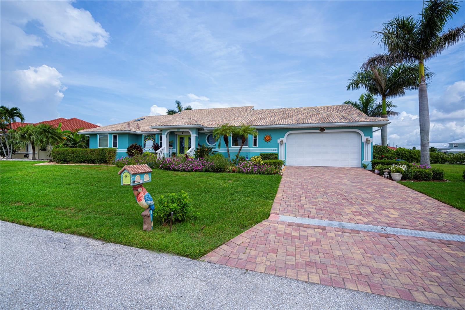 Amazing 5bedroom home with a 6 car attached garage with epoxy floor situated on a huge double lot with sailboat access to Charlotte Harbor. This Punta Gorda isles home boasts over 3000 ft. of air condition living space with approximately 95 feet of seawall on a sailboat water canal granting excellent access to the Charlotte Harbor and the Gulf of America. Arriving at this home you’ll be greeted by magnificent landscaping. The custom tropical design double entrance doors and impact glass windows, shutters on stained glass in the front. All this opens to a huge great room with soaring ceilings, porcelain tile floors, an awesome chef style kitchen with granite countertops. Four bedrooms downstairs including a huge primary bedroom suite. Adjacent to the primary bedroom suite is another bedroom that is currently used as an office/den. To access the fifth bedroom, you’ll be guided up the open staircase, which is a great place for guest or a great place to go to enjoy peace and tranquility overlooking the commanding view of the canal. The six-car garage has high ceilings and is perfect for the car guy or car girl that just wants to have room for all their toys. The adjacent lot included in the price can be divided and can accommodate a very large home if so desired. Make your appointment today to see this fabulous home and I’m certain you will want to make this home your own. This is a one-of-a-kind home in this area.