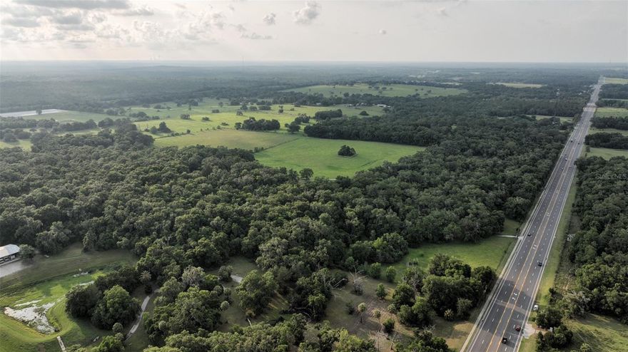 The moss draped live oaks at the entrance to the subject property is 167+- acres located at 2448 South Lecanto Hwy, Lecanto, FL. make a spectacular entrance. The property contains beautiful rolling hills. At the subject site Lecanto Hwy is a 4 lane road with a middle turn lane offering access from both directions.

From an understated entrance on South Lecanto Highway, the paved driveway winds through moss-draped live oaks and longleaf pines leading to beautiful rolling pastures on this hidden gem.  Located in unincorporated Citrus County, this property would make a wonderful large estate. It also contains a modern 3,847 SF residence that could be used for a clubhouse or property manager's residence for a larger development.

The Citrus County Government Center, Lecanto High School, Lecanto Middle School, and Lecanto Primary School all adjoin the tract on the south side, with the Withlacoochee State Forest bordering on the west. The Property is mainly pasture, being used for cattle and hay production, and has an agricultural exemption.

Water & Sewer are adjacent to the property, which contains less than an acre of wetlands. The property has 1,336 ± FT of mostly wooded frontage on South Lecanto Hwy, a four-lane road with a middle turn lane, offering access from both directions. There are two additional entrances from West King B St from the north. 

The Zoning and Land Use are LDR, LDR MH, and PSO. The 155 acres of LDR allow up to 6 residential units to the acre with a P.U.D. The 12 acres of PSO allow for Single Family, Houses of Worship, Professional Business Office, Clinic, Strip Center, Pharmacy, Specialty Food Store, and Small Grocery Store. PSO also allows up to 10 multi-family residential units.

Beautiful rolling hills with pasture
Located on busy South Lecanto Hwy, which is four lane and has a turn lane into the property
Adjacent to Citrus County Government Center and three public schools
Land Use/Zoning is favorable for Single Family Residential Development/Manufactured Home Development/Commercial and Multi-Family Development