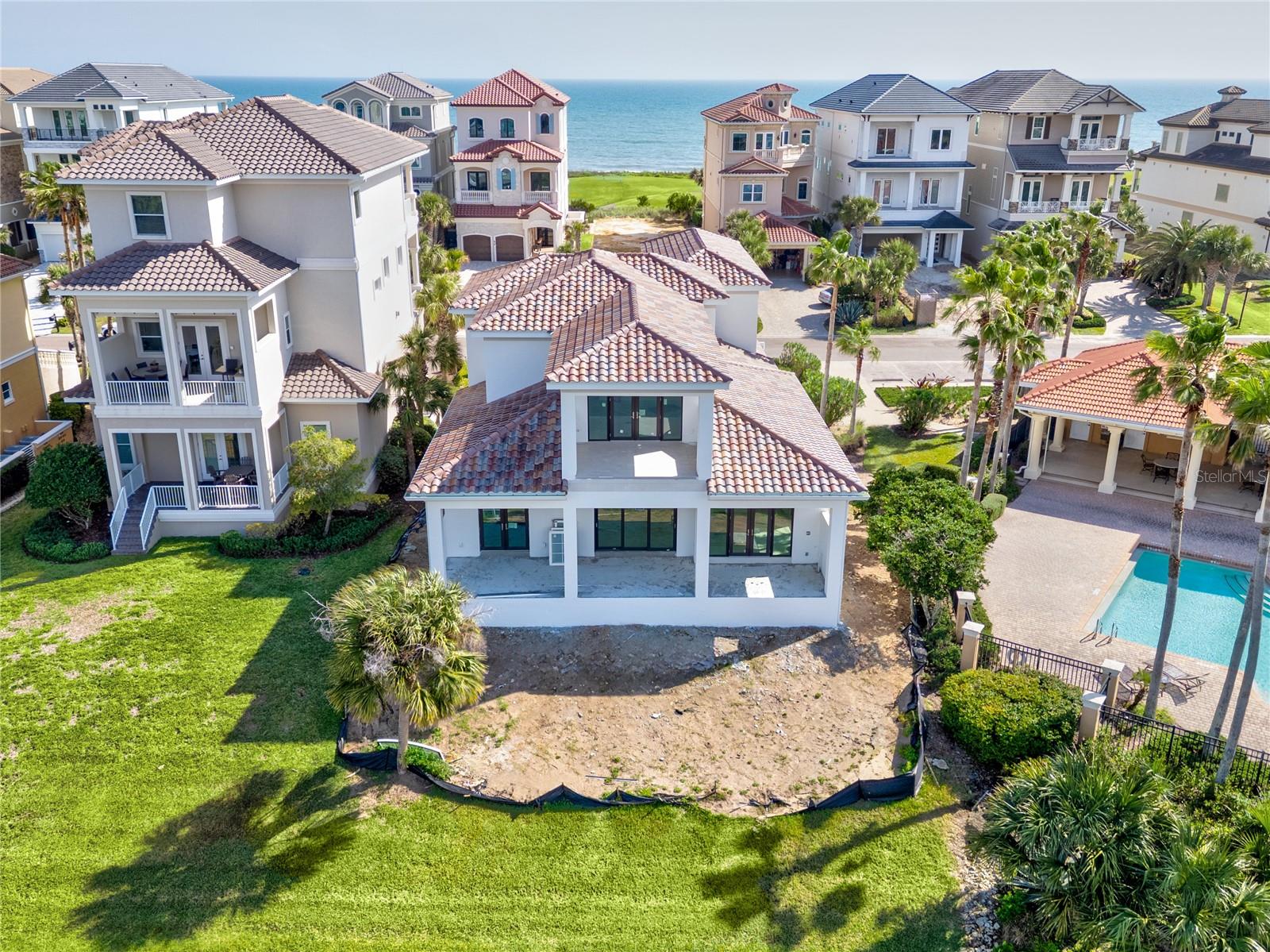 Indulge in unparalleled sophistication with this magnificent Blue Water masterpiece, situated in the prestigious Ocean Hammock community. Every element of this newly constructed home has been thoughtfully curated to seamlessly blend timeless elegance with modern functionality, offering an exceptional living experience like no other. This exceptional 4 bedroom, 4 bathroom and 3 Car Garage home is located right across from the beach access. Take a short stroll to the beach and enjoy a refreshing dip in the cool pool. At the heart of the home, the custom kitchen showcases hand-painted tile work, marble countertops, a 48" dual-fuel stove, a convenient microwave drawer, and low-voltage lighting under cabinets for a warm, modern ambiance. The main living area boasts striking 24x48" tiles imported from Spain, adding a touch of European sophistication. The open floor plan of the first living is ideal for everyday life or hosting your family and friends. Also, conveniently on the first level boasts the primary suite with two walk-in closets. Italian hardwood flooring graces the primary suite and upstairs, complementing the marble tile accents that flow throughout the home. Step into the spa-like bathroom, complete with Toto Nexus toilets, a steam shower, and thoughtfully placed under lighting cabinets. Custom molding adds an air of refinement throughout the house, while the custom wood staircase and railing create a grand focal point. Designed for ease and organization, the home features custom walk-in closets and shelving, and even a dedicated dog wash station for your furry companions in the mud room. Upstairs showcases the other bedrooms with ensuites, one being a perfect option for an office or 4th bedroom with a balcony facing East ideal to feel the ocean breezes while the sun comes up. Outdoor living is equally impressive, with custom rear patio stairs and planters that blend style and practicality. From the back patio and balcony, you will be able to soak in the stunning sunset views while overlooking the lake. This home is truly a masterpiece of craftsmanship, offering a seamless blend of luxury and comfort in every corner. It's more than a home—it's an experience waiting for you. Living on Hammock Beach Circle comprises of a guarded community gate, community pool and beach access, and lawn maintenance all included in the HOA. You can also join the Hammock Beach Club for access to world-class amenities, pools, Golf Courses, restaurants and more! Expected completion in May.