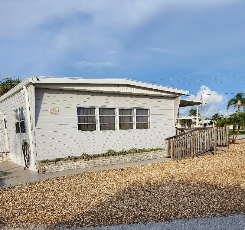 Under contract-accepting backup offers. LOCATION and WIDE OPEN SPACE! The lot is spectacular; the existing home is a bit of a fixer with unbelievable potential! Just needs TLC. This Two Bedroom, Two Bath DOUBLE WIDE Mobile Home is on an Oversized Double Corner lot in the highly desired, active 55+ Trailer Estates community. Although this home has a new roof, new vinyl siding and new skirting, the carport is missing. Ready for your updates; put your own stamp on this one. Good square footage, great open floor plan, and a large open covered side porch. Will need new subfloors and floor coverings throughout the home. Electrical, plumbing and HVAC should be checked out by licensed professionals.10x26 detached shed with washer/dryer hookups and plenty of room for storage. OR...IF YOU CHOOSE, remove the existing home and install a fabulous new manufactured home! You own the land. Boaters have direct access to Sarasota Bay from the Marina. Enjoy the large, heated community pool, hot tub, gym and wood shop. The community buzzes with pickleball, shuffleboard, kayaking, horseshoes, bocce, dancing and more. A US Post Office on site. 10 minutes to Sarasota-Bradenton Int'l Airport. Convenient to shopping, restaurants, the Arts and everything in Bradenton/Sarasota.