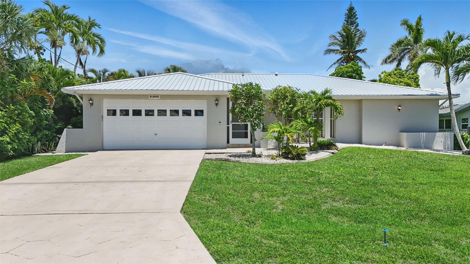 Welcome to 5305 Darby Ct, an exquisite waterfront retreat nestled in the highly coveted Yacht Club area of Cape Coral. Perfectly situated on a quiet cul-de-sac with direct Gulf access, this elevated home is a rare gem for discerning buyers seeking luxury, privacy, and boating convenience. "High and dry" through every storm, this home has never experienced water intrusion—offering peace of mind and enduring value for the future. Step inside to find a bright, coastal-inspired interior featuring an expansive open-concept layout, perfect for entertaining. The kitchen is a chef’s dream, newly updated with sleek granite countertops, white shaker cabinetry, stainless steel appliances, and a large island with bar seating. A spacious dining area flows seamlessly into the living space, while wide windows and glass doors frame tropical views and flood the home with natural light. This thoughtfully designed home offers multiple guest suites, a beautifully upgraded laundry room, and an elegant primary suite complete with a renovated bathroom showcasing a large, tiled walk-in shower. Outdoors, escape into your private screened lanai, where a heated cocktail pool with waterfall fountain and custom stone surround creates a tranquil oasis. The upgraded pool cage allows for year-round enjoyment in a lush, tropical setting. For boating enthusiasts, the home includes a captain’s walk dock with a 10,000 lb lift and boat canopy—just minutes to open water with no bridges. Additional upgrades include a two-year-old standing seam metal roof, storm shutters for all windows and doors, and mature landscaping that enhances both curb appeal and privacy. Located just moments from Cape Coral’s beautiful beaches, vibrant dining scene, boutique shopping, and the upcoming Yacht Club redevelopment, this home offers the ultimate in Southwest Florida living—whether you're seeking a full-time residence, vacation getaway, or investment property with exceptional rental potential. This is coastal living at its finest—turnkey, elevated, and ready to enjoy.