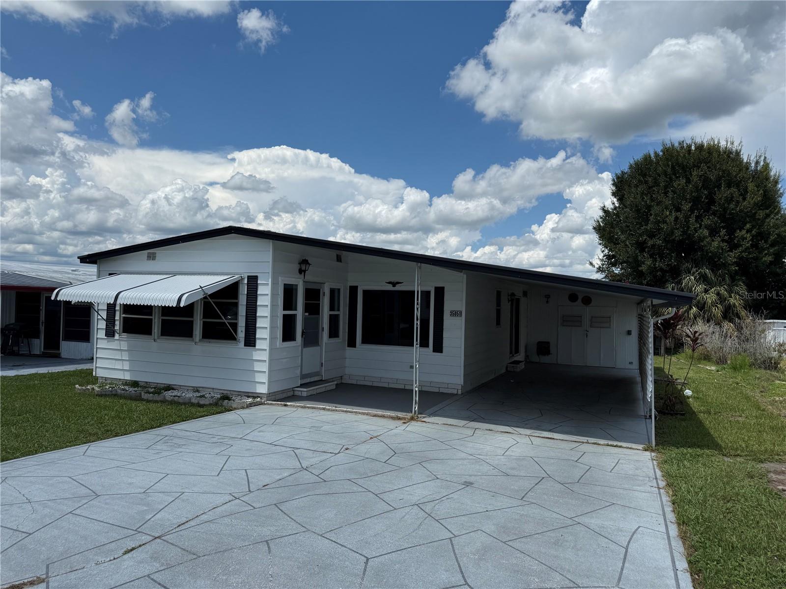 Priced for a quick sale! Welcome to Zephyr Shores located in beautiful Zephyrhills Florida Zephyr shores, is an active 55+ community where you own the land with a low HOA fee of just $600/year. This 1979 2-bedroom, 2-bathroom home has just been completely remodeled. Upon entering you will step into fully finished sunroom which flows into a spacious great room, perfect for those family gatherings. adjoining the Livingroom is a galley-style kitchen featuring new appliances, countertops, and laminate flooring, the dining area is conveniently attached which offers ease of serving and entertaining The master bedroom is quite spacious and has a private entrance/exit which leads onto a private back porch for that morning cup of coffee or those beautiful Zephyr sunsets. The master bedroom also features a spacious walk-in closet, ceiling fan, and a private bathroom with a tub/shower combo laminate flooring. The second bedroom is quite spacious, as well featuring a built-in closet, carpet, and a ceiling fan. The 10x12 attached laundry and storage room has washer and dryer, hook-ups. The home is equipped with a central AC/heating system, and the metal roof and carport provide durability and protection. Located near Hospital, churches, theater, shopping, and dining, Easy access to airports, I-75 and I-4. All room sizes are an estimate buyer/agent should verify. Schedule your private tour today