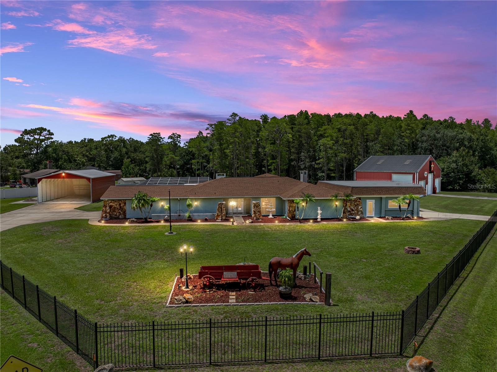 Over 1.5 acres, 11 garage spaces, a two-story workshop, sparkling pool, and your own private pond - this extraordinary Lutz property offers room to spread out, unwind, and enjoy every hobby under the sun. Ideal for large families, multi-generational living, car enthusiasts, or anyone who loves to entertain, this spectacular one-of-a-kind home is packed with standout features, including a brand new 2025 roof and water heater, RV carport, and multiple gathering spaces both inside and out. Set on a beautifully landscaped corner lot, the 3 bedroom, 2.5 bath residence welcomes you with a breathtaking layout, lush greenery all around, and a covered entryway. Step inside to discover over 5,000 square feet of thoughtfully designed living space, including four distinct living areas, a formal dining room, a full wet bar, and an open-concept floor plan that allows each space to flow effortlessly into the next. With several access points to the expansive screened pool deck, indoor-outdoor living is seamless and easy. The updated chef’s kitchen is both functional and stylish, featuring a decorative backsplash, pendant lighting, black stainless steel appliances, pantry storage, ample prep space, and breakfast bar seating. Tucked away on one side of the home, the primary suite is a true retreat with two large walk-in closets and a beautifully renovated en-suite bathroom offering stone countertops, updated cabinetry and lighting, and an accessible walk-in shower. Just off the sleeping quarters is a private office with direct access to the two-car garage, perfect for a private entry setup or work-from-home convenience. Two additional bedrooms and a full bath are located on the opposite side of the home, offering ideal privacy for family or guests. Outside, authentic Florida living awaits with a sparkling screened pool, multiple covered seating areas, a firepit zone, and tranquil views of the private pond. The garage and workshop setup is unmatched: a 2,131 sq ft air-conditioned attached second garage with tandem parking for 6, built-in cabinetry, epoxy flooring, and a tool room; plus a detached two-story workshop with 3 bays, a car lift, paint room, half bathroom, and a second-story storage loft with motorized retractable stairs. Add in the oversized RV carport and you’ve got more than enough space for all your vehicles, toys, and projects - all in a central Lutz location just minutes from shopping, dining, major highways, and everyday conveniences. This is more than just a home, it’s a lifestyle. Schedule your private showing today!