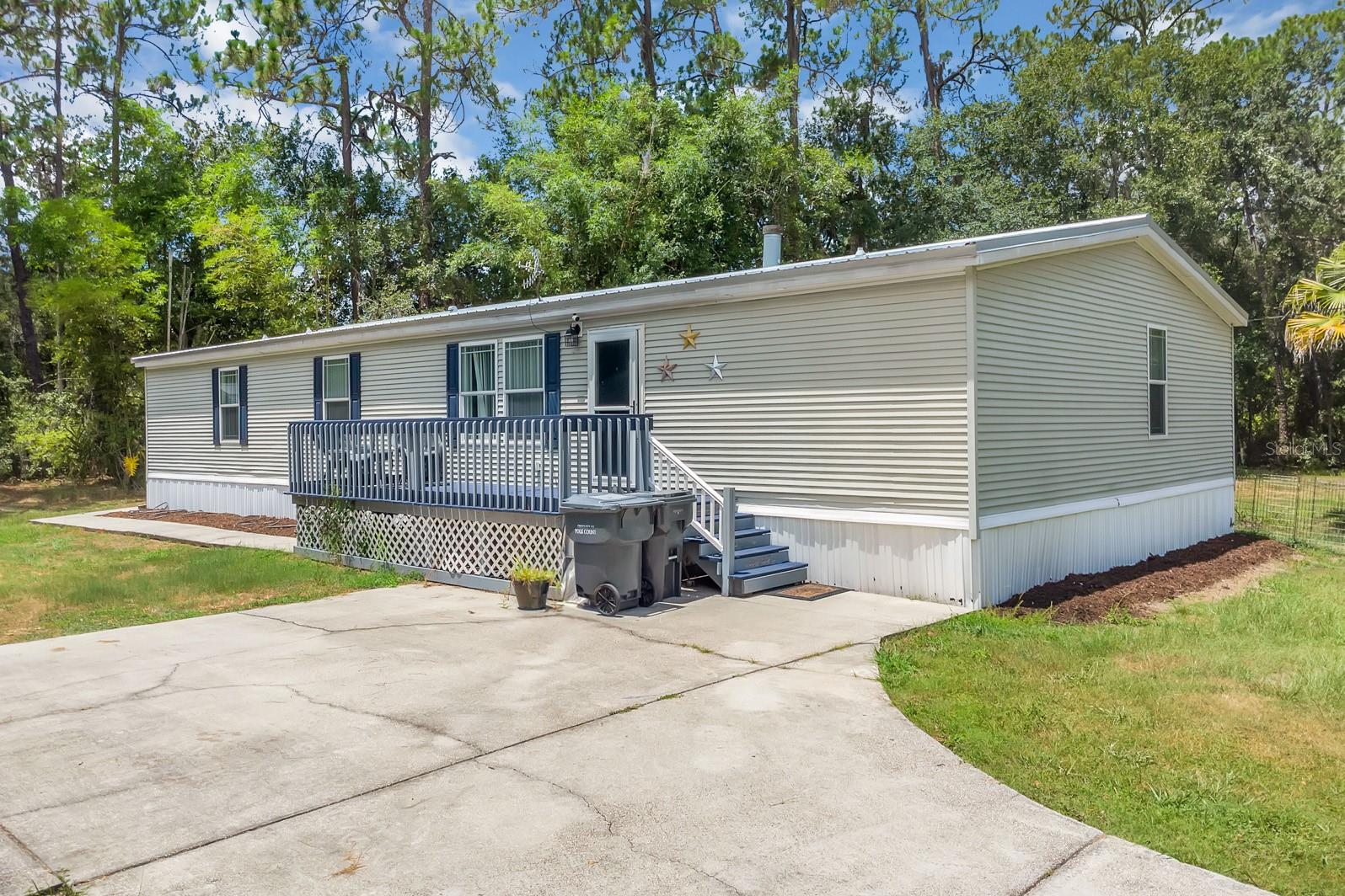 Enjoy the space and charm of this beautifully landscaped 1.23-acre property — a perfect setting for comfort, creativity, and room to grow! This inviting 3-bedroom, 2-bathroom home with 2 bonus rooms offers plenty of room to spread out, relax, and make your own. Enjoy peaceful evenings on the spacious back deck, surrounded by lush greenery, and take advantage of extra electrical hookups — perfect for RV or boat storage, or setting up ambient outdoor lighting. Inside, a cozy fireplace anchors the open living area, which flows into the dining room and kitchen for easy entertaining. The split floor plan adds privacy, with two bedrooms and a full bath on one side and a bonus room with a wet bar and sink leading to a convenient laundry room. The master suite is tucked away, featuring a walk-in closet, extra sitting space, and a roomy en-suite with double vanities and a walk-in shower. Topped off with a new roof, this home combines comfort, functionality, and long-term value. Don’t miss out — book your showing today and come explore all the possibilities this property has to offer!