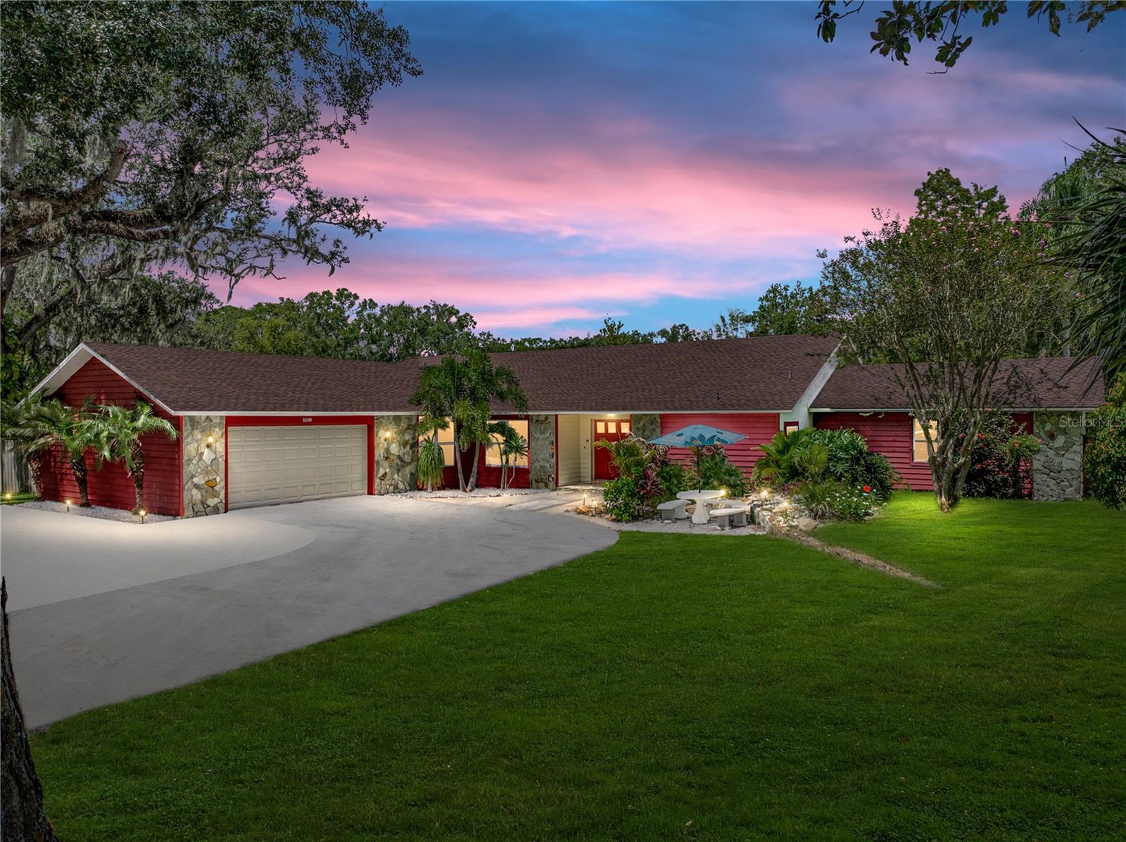 One or more photo(s) has been virtually staged. A peaceful pond stocked with fish, a sparkling pool and spa, an expansive 2,784 sq ft home set
on 1.27 acres, and a brand new roof - this is the epitome of waterfront living within Lake
Bernadette Gardens. Arrive to a mature tropical landscape, a circular drive, a Koi pond with a
waterfall feature, and a cozy outdoor seating area that all work together to present a welcoming
curb appeal. Inside this 3 bedroom + office, 3 bath, 2 car garage, pool home, an open-concept
floor plan sets the scene for indoor outdoor living and entertaining. The spacious living room
features tile flooring, a wood-burning fireplace with stone surround, vaulted wood plank ceilings
with exposed beams, 2 new ceiling fans, and triple sliding doors that open to the lanai.
Overlooking the main living areas, a formal dining room and a beautifully appointed kitchen
await, offering granite countertops, breakfast bar seating, plenty of cabinet storage, upgraded
lighting, stainless steel appliances, and an additional eat-in dinette. A formal office with sliding
glass doors to the pool deck and a double door entry sits down the hall near the home’s full guest
bathroom with a walk-in closet, a jetted tub, a granite-topped sink, and a walk-in shower. Rest
easy within your private primary suite adorned with vaulted wood plank ceilings, a large walk-in
closet, access to the outdoor spa, and an ensuite bathroom with a walk-in shower. Two
generously sized guest bedrooms are on the opposite side of the home, and they share a full
bathroom in between. Authentic Florida living awaits outdoors, with scenic water views, space to
fish from your private pier, and an oversized lanai housing the swimming pool, covered seating
areas, and spa. This tranquil setting makes every day feel like a vacation getaway. Lake
Bernadette Gardens is a centrally located Zephyrhills community with a low HOA fee and no
CDD. Call today to schedule your private showing of this one-of-a-kind property.