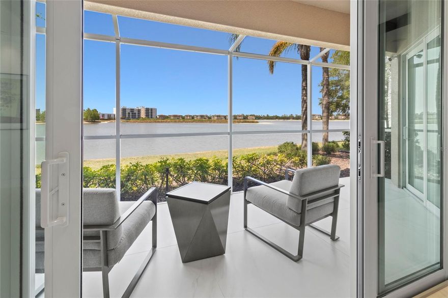 SHOWPIECE WATERFRONT RESIDENCE CONDO ON LAKE UIHLEIN – FIRST FLOOR LUXURY UNIT WITH OVERSIZED TWO CAR ATTACHED GARAGE! Leave the exterior maintenance behind and experience RESORT STYLE LIVING at its finest in this FULLY TRANSFORMED, MOVE-IN READY residence located on the serene shores of 168-acre Lake Uihlein. Situated on the coveted FIRST FLOOR, this WATERFRONT SHOWPIECE combines modern design, advanced smart-home technology, and custom details throughout. From the moment you enter, you’ll be captivated by the SWEEPING LAKE VIEWS and the light-filled OPEN FLOOR PLAN, offering an effortless blend of comfort and sophistication. Step into elegance with extra-large, artistically installed 48”x48” Carrara-style porcelain tiles—sourced from Spain and Italy—featuring a matte finish and soft gray veining. These tiles are not only visually striking but also set a seamless, high-end foundation that complements any interior style. This home is fully equipped with the latest smart technology and high-end audio, including a STATE-OF-THE-ART WHOLE HOME SURROUND SOUND system, integrated thermostat, security system, motorized window treatments, and premium lighting throughout. You’ll find flush-mounted, DIMMABLE LED RECESSED FIXTURES, designer accent lighting imported from Italy, and under-cabinet and shelf lighting in the kitchen and baths that create an ambient glow. The CHEF'S KITCHEN is outfitted with Sub-Zero refrigerator and freezer columns, Wolf double ovens, a Wolf microwave drawer, and a 30-inch Wolf induction cooktop with bridge burner—all paired with sleek CUSTOM CABINETRY that extends to the office, media center, and bathrooms. The dedicated home office features a quartz feature wall, backlit glass shelving, and ample storage for function and beauty. Additional highlights include a CUSTOM MEDIA WALL, expanded hallway cabinetry for optimal organization, and a mudroom-adjacent laundry area equipped with ASKO front-load washer and vented dryer. Enjoy your PRIVATE ENCLOSED LANAI with PANORAMIC LAKE VIEWS, or take a short stroll to Lakewood Ranch Main Street for dining, shopping, and community events. A TWO-CAR ATTACHED GARAGE with EV CHARGER adds convenience to this exceptional property. Located minutes from I-75, SRQ Airport, A-rated schools, top-rated beaches, golf courses, and University Town Center Mall, this ONE-OF-A KIND home offers resort-style living in one of Florida’s most sought-after communities. Luxury. Location. Lifestyle. Schedule your private tour today!