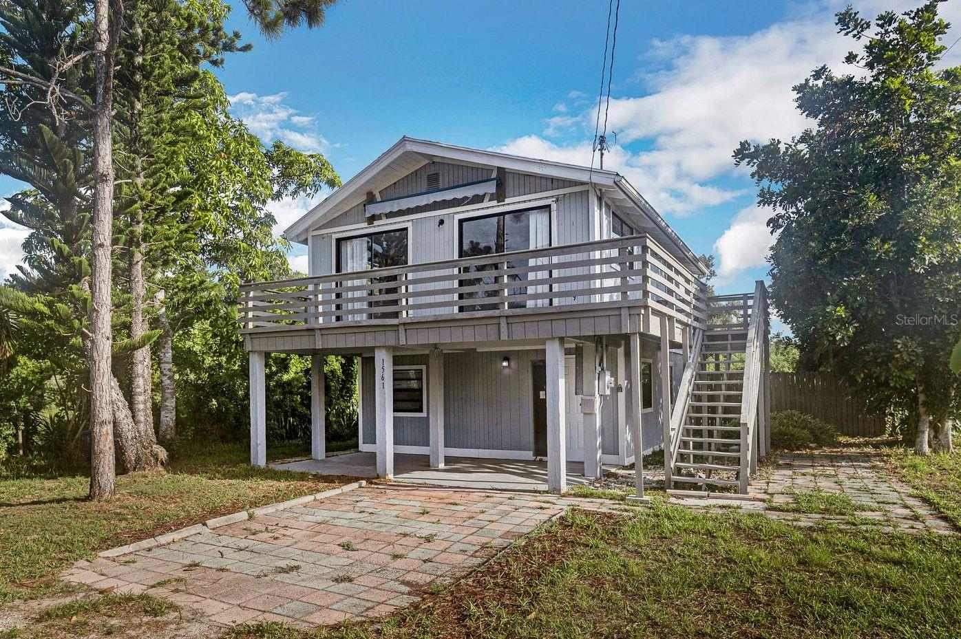 This charming 2 story is both conveniently located and tucked away for privacy. Bright and inviting, you'll appreciate the sunny outlook that this home brings. The deck overlooking the front yard with 2 patio doors ensures substantial natural light, showcasing the versatile living space. You'll appreciate the access to the spacious deck that wraps around one side of the home. Start your day with coffee on the deck then unwind by relaxing in the shade of the patio. Inside, you'll find 3 bedrooms and 2 baths, a quaint kitchen and laundry room. You will love the ease of vinyl plank flooring and tile throughout. There is also ample storage, and a paver parking area. Welcome Home!