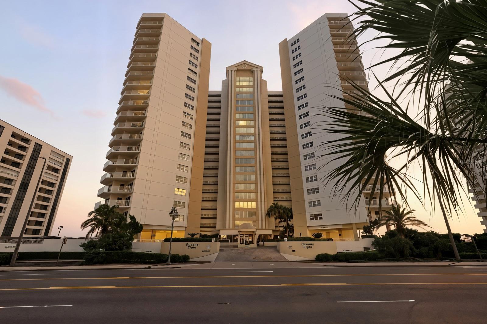 FULLY RENOVATED and FULLY FURNISHED 3BR/2BA OCEANFRONT CORNER UNIT in the coveted 03 stack at Oceans Eight! This luxurious showpiece offers panoramic OCEAN-TO-RIVER VIEWS from impact-rated turtle glass windows and a wraparound balcony—perfect for watching sunrises, sunsets, rocket launches, fireworks, and dolphins. Designer kitchen with soft-close cabinetry, porcelain countertops, and stainless appliances flows into an open living space finished with elegant 24x24 polished tile floors and oversized baseboards. Spa-style bathrooms feature floor-to-ceiling designer tile and rain showers. NEW ELECTRIC HURRICANE SHUTTERS (2025) add convenience and peace of mind. Resort-style amenities include an oceanfront pool, heated indoor lap pool, spa, sauna, and fitness center. PET-FRIENDLY with secured parking and storage. Walk to Publix, golf, pickleball, concerts, and more—LUXURY COASTAL LIVING AT ITS FINEST! Oceans Eight is widely regarded as one of the finest buildings in Daytona Beach Shores, offering premium amenities and meticulous upkeep. The lobby and social room renovations are fully funded with NO ASSESSMENTS to buyers. Residents also enjoy a car wash station, bike storage, assigned underground parking, and additional surface parking. Centrally located for easy access to beaches, shopping, dining, I-95, and I-4, this rare corner residence combines modern elegance, exceptional views, and walkable convenience in one of Florida’s most desirable coastal communities.
