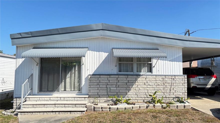 Discover the potential in this partially furnished double-wide manufactured home offering over 1,000 sq. ft. of comfortable living space. Built in 1979, this home features 2 bedrooms, 2 full bathrooms, a spacious living room, and a formal dining room with built-in cabinetry. The secondary bathroom has been updated with a new shower, and all major appliances convey—including the refrigerator, microwave, and stove.

Enjoy a mix of carpet and vinyl flooring throughout, a dedicated laundry area with washer and dryer included, and a 9x12 bonus room accessible from both the carport and the primary suite. Additional storage can be found in the 6x7 utility shed.

Located in a friendly 55+ resident-owned community, residents have access to great amenities such as a clubhouse and shuffleboard courts. All of this in a prime location close to shopping, dining, and the beautiful Gulf Beaches.