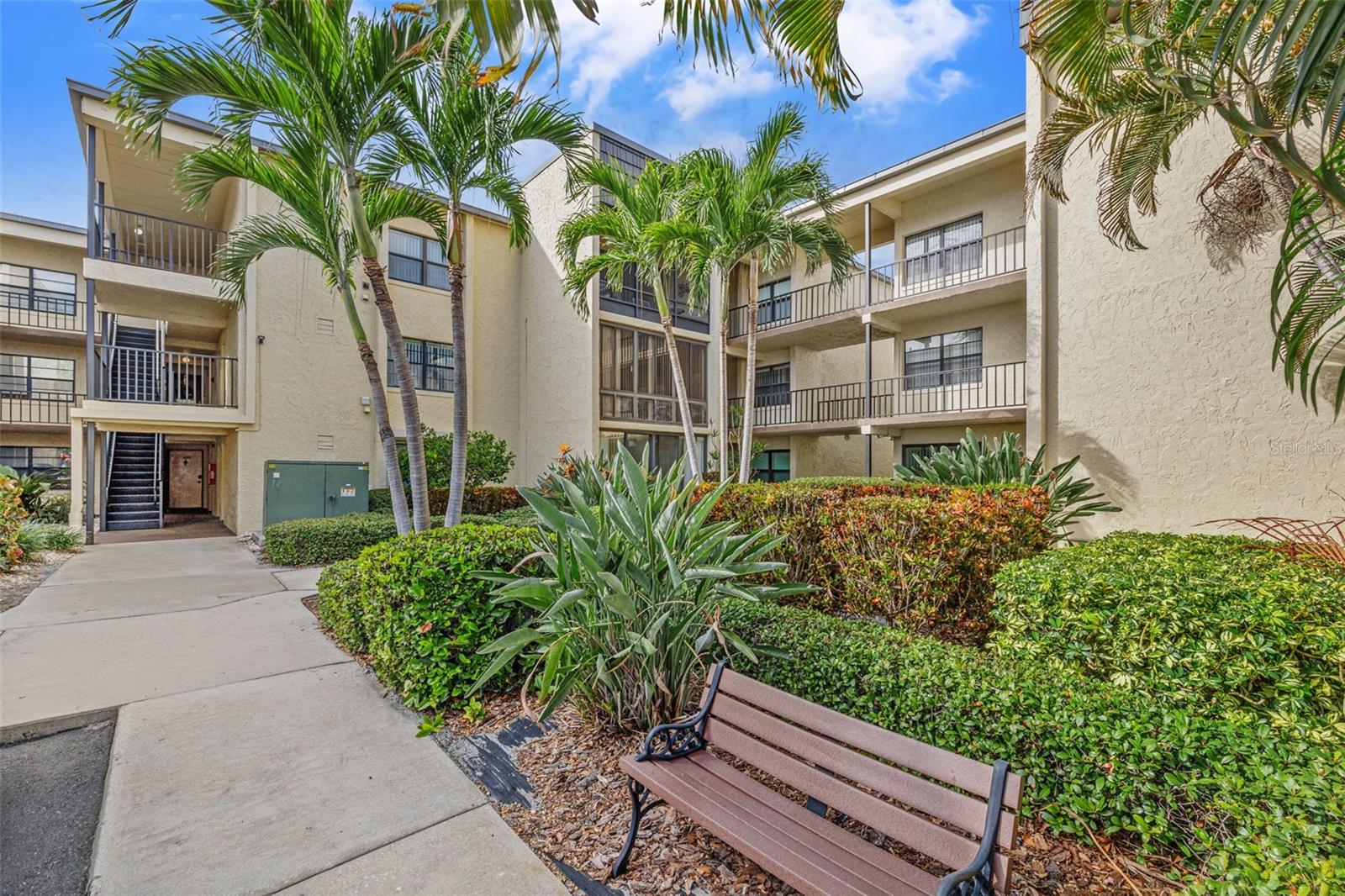 Welcome to Your New Florida 55+ Retreat! Discover the perfect blend of comfort, style, and convenience in this beautifully updated 1-bedroom, 1.5-bath condo. From the moment you step inside, you’ll notice the tasteful upgrades, including shaker cabinets, butcher block countertops, and two completely renovated bathrooms. Additional peace of mind comes with a new hot water heater, updated electrical panel, and a newer AC system. Start your mornings in the bright sunroom, adding additional living space, overlooking a serene pond with a fountain—the perfect spot for coffee, reading, or simply soaking in the view. Laundry is just steps away, making day-to-day living effortless.
This vibrant 55+ community offers a true Florida lifestyle with 3 sparkling pools, a shuffleboard court, and welcoming common areas for socializing with neighbors and guests. Nature lovers will appreciate scenic walking paths, a charming bridge over the pond, and beautifully maintained grounds that invite you outdoors year-round. Centrally located near shopping, dining, and just minutes from the beach, you’ll have everything you need right at your fingertips. Whether you’re looking for a seasonal escape or a full-time residence, this condo is the one you’ve been waiting for! Don’t miss your chance to own this move-in ready gem! Schedule your showing today!
