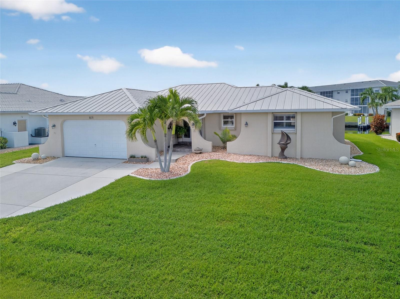 PUNTA GORDA ISLES!! BEAUTIFUL 3 BEDROOM, 2 BATH, 2 CAR GARAGE WATERFRONT POOL HOME with powerboat access to Charlotte Harbor leading to the Gulf! Private dock and boat slip, complete with 10,000 lb. lift with water and electricity. Beautiful curb appeal with new landscaping, newer roof 2023, and irrigation system. Step inside through beautiful double door entry where you will find an open floor plan with high ceilings and multiple sliders to the screened lanai with beautiful intersecting canal views, contemporary décor and lighting. The kitchen offers two-toned cabinetry, granite countertops, windows overlooking pool, large island and breakfast bar great for entertaining and hosting. Generous primary bedroom has slider access to lanai/pool area, ample natural light, his and her walk-in closets and private en-suite bath featuring dual vanities, soaker tub, tile walk-in shower, and private water closet. Split floor plan provides privacy for guests with two additional bedrooms and separate full bath. Additional highlights include plantation shutters, all new ceiling fans and sink faucets throughout, concrete aprons on driveway for additional parking, rescreened pool cage 2023, epoxy garage flooring 2025, hurricane windows and accordion shutters for maximum hurricane protection, private dock and boat slip, breathtaking water views—perfect for fishing or simply soaking in the beautiful surroundings. Outdoor entertaining area features covered lanai with heated screened pool including an extended walkway to the dock with lift and 80' of water frontage. In a popular golf and boating community close to St. Andrews South Golf Club, the Yacht Club, Fishermen's Village, and the historic downtown area of Punta Gorda. Enjoy access to arts, community events, entertainment, world-class fishing, boating, fine dining, and beautiful parks, as well as easy access to the SWFL gulf beaches. Don't miss your chance to own this waterside treasure! Schedule your private showing today!