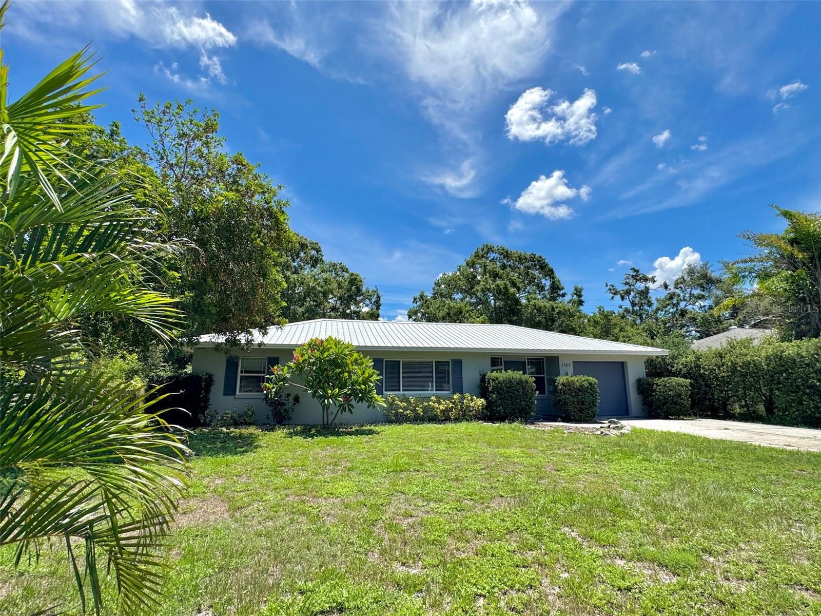 This great home at 1507 30th St W. offers 1,455 sq ft of inviting living space with an open floor plan and fantastic natural light throughout. Plenty of room for office or den and you can also put 3rd bedroom back! You will love this clean, solid block, Move-In Ready property in the Heart of Bradenton close to Manatee High School! This house has character with the arched doorways, spacious living room and separate dining area. The bedrooms have wood/laminate floors, ceiling fans and cedar closets, bathroom is updated, kitchen has solid oak cabinetry, breakfast bar and large bonus Florida room for family fun and activities. Enjoy the newly updated AC and duct work (with a transferable 10-year warranty) to ensure you stay cool and comfortable year-round! Step outside and fall in love with the spacious patio and private large backyard — perfect for weekend BBQs, outdoor entertaining and cozy nights by the fire pit under the stars. The patio was constructed with footers for any future expansion needed. There is a 1 car garage with built in storage areas and wide access driveway for extra guest parking. The metal roof provides long-lasting durability from the Florida weather. All this, plus a prime location near MHS, shopping, restaurants, beautiful Gulf beaches and everything else Bradenton has to offer! This clean, move-in ready home is just waiting for you to make it yours. Don’t miss out — schedule your showing today!