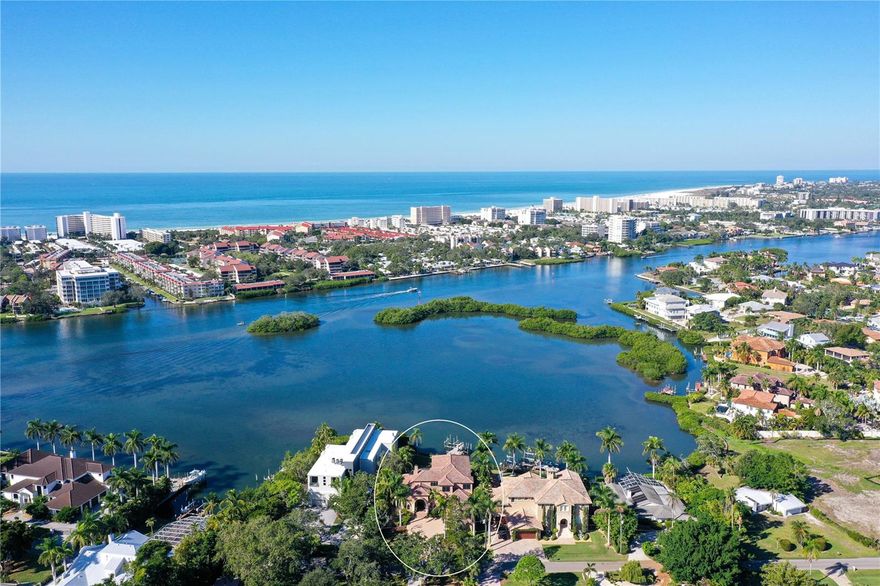 Nestled in the prime spot of Sarasota, just a stroll away from Siesta Key, this stunning Bayfront residence occupies its own serene enclave on Little Sarasota Bay, seamlessly connected to the Intracoastal Waterway. Tucked away at the end of a secluded road, the house boasts ample front and back lawns, offering exceptional sunset panoramas. 

The main floor hosts a waterside office and three bedrooms, including the master, with one room versatile enough to serve as an exercise space. Upstairs, two additional bedrooms accompany a generously sized game room and a theater room boasting a 12-foot-wide screen. A broad dock equipped with a boat lift and jet ski pair lifts, offering over three feet of depth, provides easy water access with steps for convenient kayak entry. This custom-designed floor plan maximizes outdoor living, boasting over 7,000 square feet under roof across both levels.

Indulge in the allure of the pool and spa area featuring a waterfall, authentic stone flooring and columns, granite countertops, top-of-the-line plumbing fixtures, and stainless appliances from Wolf and Subzero. Italian roof tiles, an office complete with a wet bar, and a spacious upstairs game room with a bar area leading to a large upper deck further enhance this luxurious abode. The downstairs covered lanai invites outdoor dining with a screened eating area and an outdoor kitchen featuring high-bar seating.

With 14-foot-high ceilings throughout the main and upper levels, this home also features a 3-car garage, a lawn sprinkler system utilizing a water well, and complete hurricane protection including Cleartek window shields, Crimesafe screens, and built-in sliding door shutters.