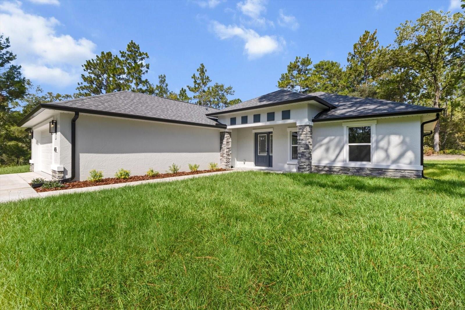 This stunning new construction home offers 1,907 square feet of thoughtfully designed living space with modern elegance and comfort in mind. Featuring three spacious bedrooms with beautiful coffered ceilings and two full bathrooms, this home combines style and functionality. The master suite is a true retreat, complete with a huge walk-in closet and a luxurious ensuite bath with a walk-in shower. The expansive great room showcases a cathedral ceiling, creating an open and inviting atmosphere that flows seamlessly into the heart of the home. The kitchen is both stylish and practical, featuring a sleek hood vent over the stove, a charming farm sink, and a convenient pantry for extra storage and organization. A large lanai extends your living space outdoors—ideal for relaxing or entertaining. A versatile craft room offers the perfect space for hobbies, a home office, or additional storage. The exterior of the home is equally impressive, with eye-catching stonework on the front that adds curb appeal and timeless character. Additional highlights include an inside laundry room for everyday ease and a two-car garage equipped with side-mount openers. Whether you’re looking to relax or entertain, this home offers the space, design, and features to fit your lifestyle.