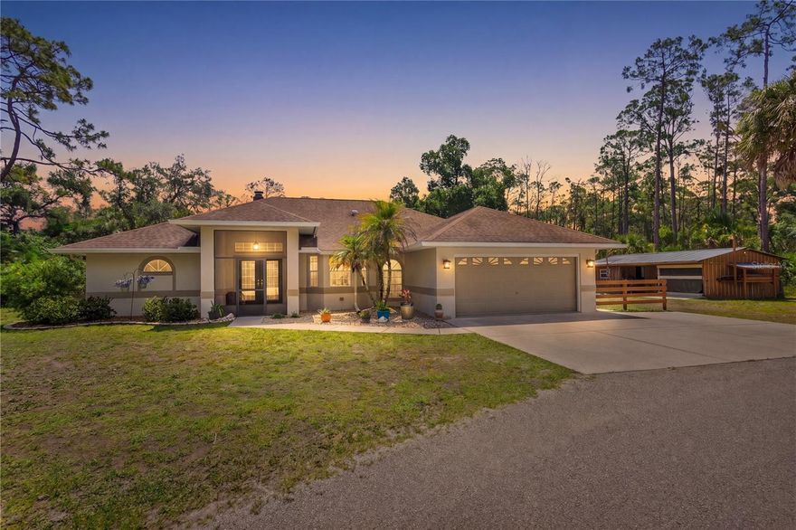 Welcome to peaceful country living at its finest in North Port Estates!  This home boasts Pride of Ownership, a well loved and well maintained split plan with 3 bedroom 2 bath with 1817 square feet under air. Situated on 3+ high and dry acres. This property combines comfort, privacy and endless possibilities. Enter through the decorative arched gate to your circular driveway. Double door entry to the home. The open floor plan and vaulted ceiling gives a sense of grandeur coupled with the bright and light atmosphere. Beautiful Coral fascia wood burning fireplace adds to the beauty of the living and dining room combination. The dining room has a lovely bay window.  The very spacious and private primary suite boasts a large walk in closet and sliding doors to the lanai. The master bath was recently remodeled to include an enclosed glass shower, separate commode room and granite double sinks. Kitchen was remodeled and boasts custom look ivory wood cabinetry, and plenty of it ... plus a floor to ceiling shelved pantry. Counters are all granite and flooring is travertine tile. Very elegant!   Kitchen has reverse osmosis both at sink and refrigeration system.  Laundry room provides convenience with built in cabinetry,  washer and dryer and entrance to two car garage, where there is also a utility sink. There is also a whole house water softening system. The bonus storage shed/workshop area  which has both electric, water, and a 12,000 BTU a/c unit is the perfect place to work on your favorite projects! The sliders to the pool are hideaway and the entire wall opens up to the fabulous pool and lanai. This pool has both a heater and cooling system making it easy to enjoy the space regardless of the time of year. The screened in area also has an outdoor shower. This spacious lanai is perfect for entertaining or relaxing while taking in the peaceful surroundings.  The expansive property provides plenty of room for farm animals, recreational vehicles, boats, trailers or all of your outdoor toys.So much potential in this agriculturally zoned property. You'll love the natural sights of local wildlife who will occasionally stop by for a visit. More good news ... there is No HOA! Location is outstanding. Minutes to I75 and also the new Sarasota Memorial Hospital which is slated to be completed by September 2027. Close enough to shopping, restaurants, golf courses, medical facilities and numerous Gulf Beaches yet distant enough to enjoy peace and quiet.  Just about 45 minutes to both Fort Myers Airport or Sarasota and about 30 minutes to Punta Gorda Airport. Whether you're looking for a private homestead, space to spread out or simply room to enjoy the outdoors, the property offers the ideal blend of country charm and convenience to all types of amenities.