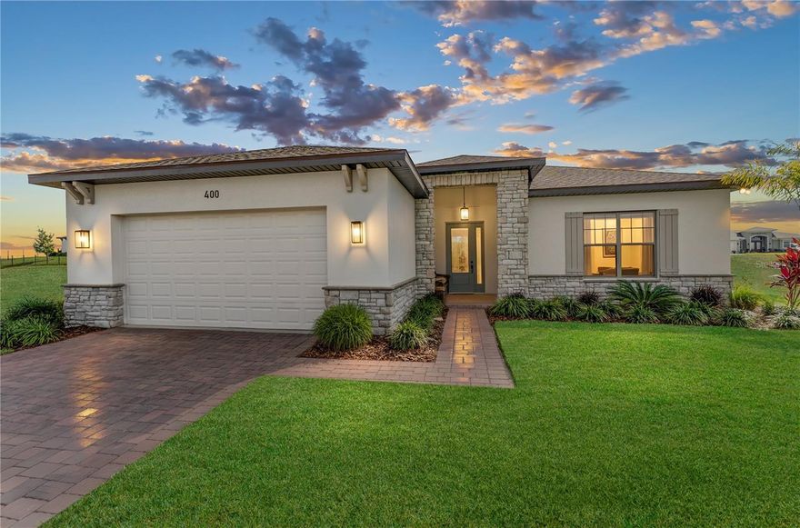 Experience the rare elegance of a single-story luxury home where architectural intention, polished design, and effortless living come together in perfect balance. This custom-enhanced 2023 residence in the gated, lakefront community of Water Ridge has been elevated far beyond builder standards, offering an exquisite alternative to oversized, high-maintenance luxury properties. Water Ridge has two private boat ramps within the community. One serves Lake Van, a 595-acre private lake, and the other serves Lake Alfred, a 676-acre public lake. A benefit to residents is on-site, secure boat storage (just $150 YR). From the moment you enter, refined simplicity takes center stage. The great room showcases a dramatic floor-to-ceiling stone fireplace, enhanced by a warm light-washed cedar coffered ceiling and expansive Brazilian 24"×24" porcelain tile that creates a seamless, gallery-like flow. Every space is thoughtfully crafted—no wasted rooms, no unused square footage—just purposeful design and uncompromising quality. The chef-inspired kitchen delivers a luxury level of sophistication: Quartz countertops, LED-lit frosted glass cabinetry, a stainless steel hood, expanded pantry with roll-outs, and an exceptional appliance suite highlighted by a Bespoke "Morning Blue" glass refrigerator, steam-convection oven with air-fry capability, and a professional digital cooktop. The result is a kitchen that blends performance with quiet luxury. Step outside to a 659 sq. ft. slate-texture paver terrace, offering an elevated outdoor living space ideal for morning coffee, evening gatherings, or serene relaxation. Lush palms and magnolias create a sculptural landscape framed by a sleek fence, delivering beauty with minimal upkeep. Ideal for the luxury buyer who values efficiency, aesthetics, and low-maintenance living, this home provides all the elegance of a high-end residence without the energy costs, upkeep, or unused rooms of larger estates. Water Ridge enhances the lifestyle with exclusive amenities. Enjoy two resort-style pools, a lap pool, pickleball, basketball & tennis courts, a state-of-the-art fitness center, fitness classes, scenic walking/biking trails, a recreation field, onsite secure boat storage, and access to multiple lakes and watersports. Gated access and a prime Central Florida location offering both sophistication and convenience. A truly refined one-story home, designed for those who seek quality, intention, and a luxurious yet effortless way of living. Be sure to view Storybook & Virtual Tour in MLS.