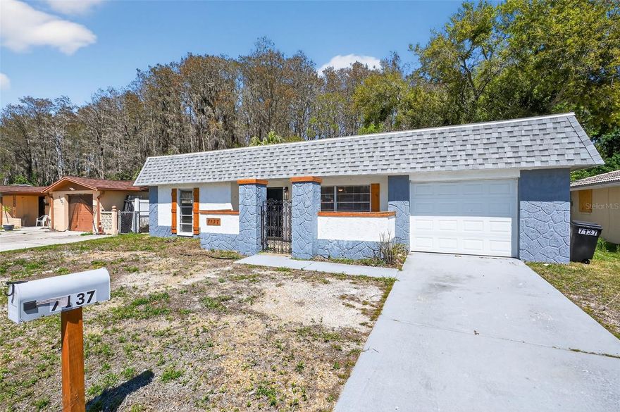 Experience modern ranch-style living in this beautifully updated 3-bedroom, 2-bathroom home in the Gulf Highlands community. Spanning 1,128 finished square feet on a .150-acre lot, this residence features a seamless open-concept main living area with durable engineered hardwood flooring throughout. The kitchen serves as the heart of the home, featuring a granite-topped island, a refrigerator, microwave, and oven/range. Retreat to the primary suite, which includes a private full bathroom and a walk-in closet. Exterior features include a front-facing one-car garage and a fenced backyard. Located within minutes of Werner-Boyce Salt Springs State Park, local shopping, and Gulf Highlands Elementary, this property provides a move-in-ready environment in a prime Port Richey location.