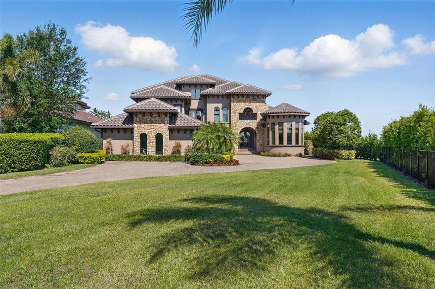 Lakefront Luxury in Winter Garden – A Rare Opportunity to wake up to breathtaking waterfront views in this custom-designed, professionally decorated and furnished, 8,838 square feet under roof and 5,178 heated and cooled (4 large bedrooms with ensuite baths plus a separate office and a half bath) lakefront estate, set on the largest lakefront lot in Summerlake. With two stunning waterfront vistas—one overlooking an exclusive private ski lake and the other offering direct access to Lake Hancock—this home is an unrivaled sanctuary for luxury, adventure, and relaxation. Step inside to soaring 22-foot ceilings, floor-to-ceiling glass doors, and a seamless indoor-outdoor living experience featuring integrated motorized screens, offering the flexibility to fully open the space to the outdoors or create a private retreat at the touch of a button. Step into your own private resort-style oasis, where the backyard boasts a custom pool with a cascading waterfall and hot tub, an in-ground trampoline, and a cozy fire pit perfect for evening gatherings. Two-tiered lanais offer ample space for relaxation, with the lower level set back to create an expansive covered area highlighted by a stunning double-height, stone-clad gas fireplace. Large sliding glass doors enhance the seamless indoor-outdoor flow, while remote-controlled screens allow the space to be fully open or comfortably enclosed. The oversized dock with increased lift capacity and Trex decking for durability provides direct access to Lake Hancock’s adventure-filled waters. Located in the sought-after Hamlin community, you are minutes from boutique shopping, fine dining, top-rated schools, and Orlando’s best attractions. This is not just a home—it’s a statement of prestige and exclusivity. Additional Highlights: This exceptional residence offers a chef’s dream kitchen featuring a premium Monogram appliance suite, including a 48in refrigerator, 36in gas range/oven, 30in electric oven, an Advantium microwave, warming drawer, and dual Bosch dishwashers. A fully equipped summer kitchen enhances the outdoor entertaining experience with a 36in natural gas grill, prep sink, and full-size refrigerator. Luxury meets functionality throughout the home with professional interior design, a stand-alone hard-wired surveillance system, a secure room, and comprehensive smart home security. Enjoy comfort and convenience with a programmable, zoned HVAC system, a commercial-grade whole-home water filtration system, and an oversized garage with a driveway that offers ample parking for guests. Craftsmanship is evident in every detail - from thoughtfully selected materials, custom wall treatments, hand-carved beams and stair treads to stain-grade interior trim and custom millwork. Additional features include: integrated sound system, custom window shades and designer draperies, drawer dominant base cabinetry and soft close hardware at all cabinetry, custom closet systems and ample storage throughout. Also includes energy efficient natural gas appliances – no propane tanks needed (interior/exterior fireplaces, range/oven, dryer, dual tankless water heaters, summer kitchen grill), architecturally detailed exterior with real thin veneer stone (not cast), concrete-coated window/door trim, and corbels, and app-controlled pool equipment and lighting. And so much more—truly too many amenities to list.