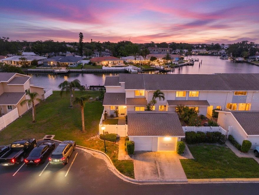 Welcome to 6537 Cape Hatteras Way NE #1, where effortless coastal luxury meets thoughtful, top-to-bottom renovation in the coveted Mariners Pass waterfront community. Perfectly positioned just steps from the heated pool and framed by serene water views, this 3-bedroom, 2-bath residence with a private 1-car garage offers a rare blend of tranquility, design, and convenience—crafted for the most discerning buyer seeking a turn-key St. Petersburg lifestyle. From the moment you enter, you’re greeted by a light-filled interior defined by clean lines, elevated finishes, and seamless indoor-outdoor flow. The designer kitchen is a true centerpiece, appointed with quartz countertops, soft-close shaker cabinetry, a GE stainless steel appliance suite, and a striking Kraus sink—all illuminated by sleek recessed LED lighting and complemented by smart lighting controls throughout. Wide-plank LVP flooring carries effortlessly from space to space, while custom window treatments add a refined finishing touch. Every detail has been curated, from the hidden hot water heater to the fully reimagined bathrooms that exude spa-like sophistication. The flexible floor plan offers a highly desirable ground-floor bedroom and full bathroom—ideal for guests, multigenerational living, or a private office retreat—while upstairs accommodations provide comfort and privacy. A dedicated laundry room enhances everyday functionality, and modern systems including a 2023 Ruud HVAC, Ecobee thermostat, water softener, Ring doorbell, and Yale smart lock deliver both efficiency and peace of mind. Step outside to your turfed private courtyard—perfect for morning coffee or evening cocktails—or unwind on the covered back patio as you take in calming water views and coastal breezes. With direct proximity to the community’s heated pool and access to Mariners Pass’ waterfront amenities, every day feels like a resort escape. Whether you're seeking a full-time residence or a refined coastal retreat, this exceptional offering delivers luxury, lifestyle, and location in perfect harmony. Call today for your private showing!