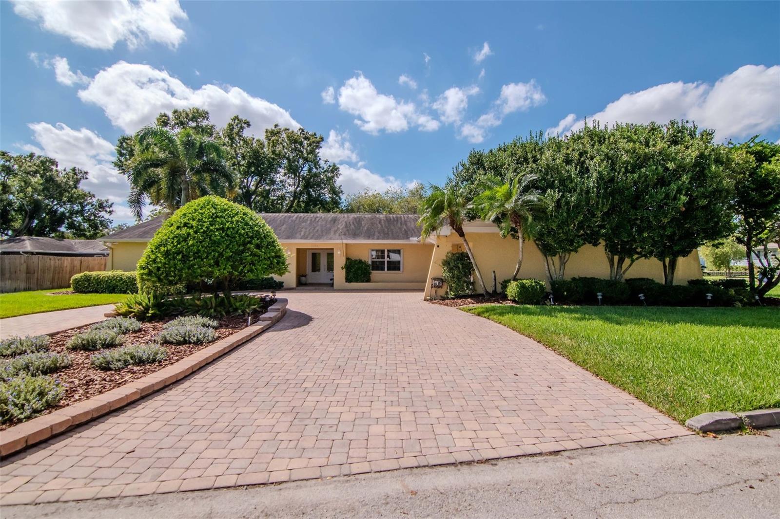 On a quiet street in West Riverside Heights sits a home that feels less like a listing and more like a family story — one carefully written by the same owner who built it for his loved ones in 1978 and tenderly preserved ever since. Location is the first chapter: this is truly one of Tampa’s best — 3 miles from the airport, 4 the shops and charm of Hyde Park, 6 miles to Downtown and close to River Walk,Water Street and Ybor. Whether your life moves by plane, play, or city nights, everything important is close at hand.
Step inside and the story turns modern. The interior has been fully reimagined with thoughtful, contemporary finishes while keeping the warmth of a home. New wood-plank tile runs underfoot guiding you to a kitchen that becomes the scene-stealer: a whopping 21' x 16' chef-sized space anchored by a large island, all-new solid wood cabinetry, quartz counters, and brand-new appliances — the kind of kitchen where holiday dinners and weekday spillovers both feel effortless.. French doors lead out to the large backyard. Outside, the plot is its own quiet subplot: a mature, thoughtfully planted landscape that feels intentional and private — a garden you could never buy off the shelf. Enjoy mornings beside the fountain, sip evenings on the patio while the yard hums gently with life, and appreciate how rare it is to find such an oversized lot in this pocket of Tampa. A paved roundabout driveway and two-car garage make comings and goings easy.
One of the home’s unique features is the attached in-law apartment. A large living room, kitchenette, and full bedroom and bath, it’s ideal for multigenerational living, long-term guests, or a private retreat for an adult child or parent. In short: a home this large, this upgraded, and this well cared for is a rare find, and it’s ready for its next family to add a few chapters of their own.