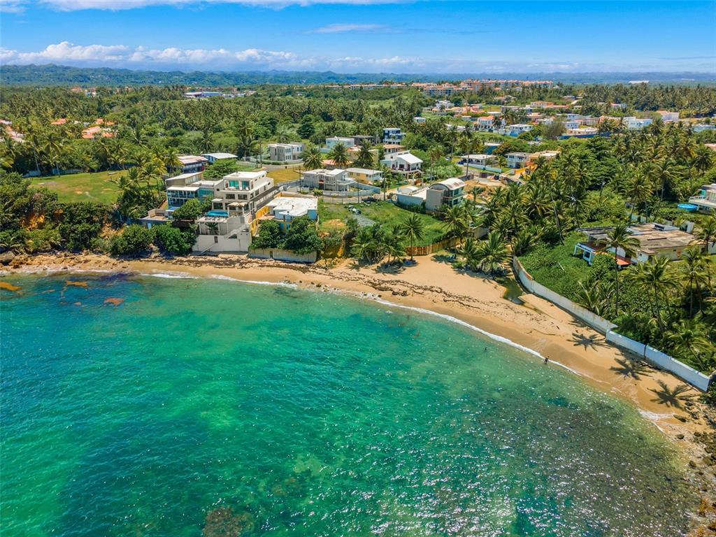 Oceanfront lot in the highly sought after Breñas community. Walk directly onto your personal beach located within a protected cove that is perfect for paddleboarding, swimming, fishing and snorkeling. This property offers 452 square meters of land with over 60 feet of beach frontage and overlooks Playa Tocones - a hidden beach paradise five minutes from the Dorado Beach Ritz-Carlton Reserve - and presents a prime “build your dream home” development opportunity. Existing plans call for the replacement of the current home with a 3-story, oceanfront masterpiece. Just imagine enjoying the sites and sounds of warm turquoise water stretching out across the Caribbean Sea in your own private paradise. This gem is situated minutes from a new hospital, restaurants, shopping, and one of the best private schools on the island.
Exterior and interior architectural renderings of a new 3-level oceanfront home with a spectacular 360-degree rooftop terrace are included to provide the discerning buyer an immersive experience for how their future home could look. For the right buyer, the seller is also willing to complete removal of the existing structure and construction of this stunning home.