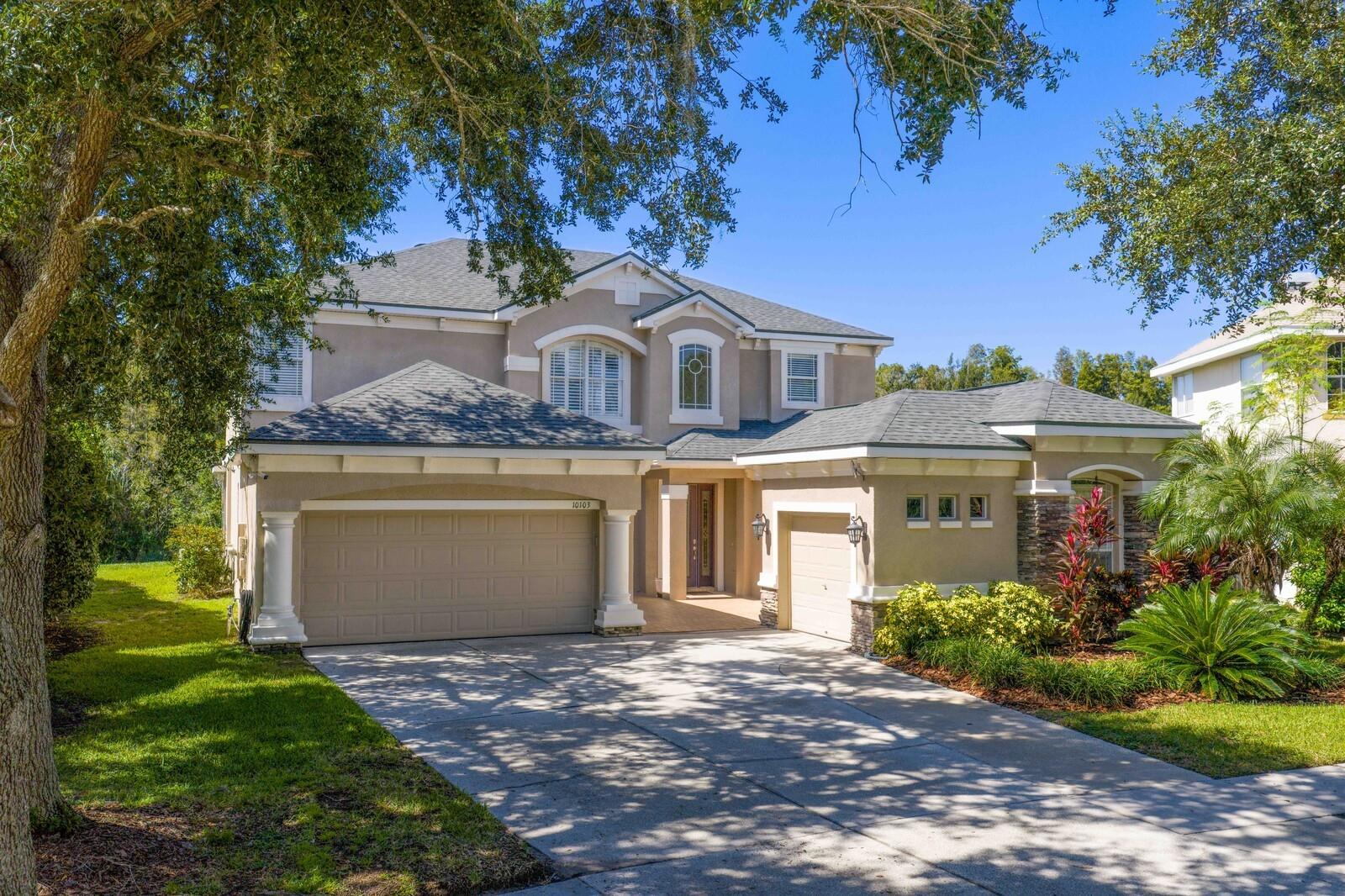 Welcome to this stunning residence in the gated Arbor Greene community.
Located within the sought-after Parkview Village, this custom-built home is perfectly positioned on an oversized lot at the end of a quiet cul-de-sac with expansive conservation views and a community open space directly across from the home for added privacy and a park-like setting.Offering 5 bedrooms, 3.5 baths, a theater room, and a game room, it delivers the space and flexibility today’s buyers crave.
The inviting courtyard entry and separate three-car garage create a warm first impression. Step through the leaded, beveled-glass door and you’ll immediately feel the difference: soaring two-story ceilings in both the entry foyer and family room flood the home with natural light.
Beautiful finishes include engineered wood flooring in the formal dining room, oversized baseboards, and 18x18 tile laid on the diagonal throughout the foyer, kitchen, family room, and breakfast nook. A stack-stone wood-burning fireplace with wood mantle and built-ins anchors the family room.
The gourmet kitchen is a chef’s dream, showcasing 42” maple cabinetry with dental molding and glass-front uppers, granite countertops, stainless steel double ovens, a walk-in pantry, and pendant lighting. The adjacent breakfast nook overlooks the lanai and lush backyard, while the powder bath is conveniently located just off the main living space.
Flexible living continues on the main floor with a bonus room featuring double-door entry, a guest bedroom with custom built-in bookshelves, and an in-home theater room (accessories included), perfect for entertaining.
Upstairs, rich wood flooring flows throughout all bedrooms. The primary suite offers a luxurious retreat with a custom walk-in closet, granite-topped maple cabinetry, a pebblestone shower, and an oversized jetted Jacuzzi tub. All secondary bathrooms have been updated with granite as well. A utility closet upstairs provides added convenience.
Outdoor living is equally impressive. A spacious lanai with built-in grill overlooks the large, private backyard and wooded conservation views — ideal for gatherings or quiet evenings alike.
Residents of Arbor Greene enjoy resort-style amenities including a fitness center, lap pool, resort-style pool with slide, tennis and basketball courts, dog park, playgrounds, and miles of scenic walking trails, all with modest HOA fees.
This extraordinary Parkview home combines luxury finishes, thoughtful upgrades, and a prime location just minutes from top-rated schools, shopping, dining, I-75, I-275, and USF.