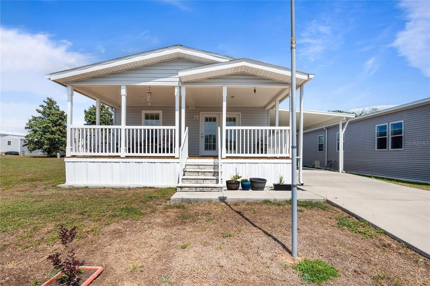 Newer 2-bedroom, 2-bath Jacobsen Homes double-wide manufactured home located in a desirable 55+ gated community in Dade City. Thoughtfully constructed with 2x6 exterior walls for enhanced durability and energy efficiency, this 2020 home offers a bright, modern interior with an open layout, luxury vinyl throughout, and an elegant tray ceiling that enhances the main living space. Designed for both comfort and functionality, the open-concept floor plan seamlessly connects the living room, dining area, and kitchen—ideal for entertaining or everyday living. The kitchen features a breakfast bar, tile backsplash, stainless steel sink, and contemporary finishes. The split layout provides privacy, with the primary suite positioned at the end of the hallway. The spacious primary bedroom includes luxury vinyl flooring, a large walk-in closet, and an en suite bathroom featuring a double vanity and custom oversized tiled step-in shower. The guest bedroom is generously sized and offers ample closet space. An interior laundry room is conveniently located near the bedrooms and leads to a side entrance. Outside, the oversized driveway accommodates multiple vehicles, and an extended slab provides the perfect space for outdoor entertaining. In addition, enjoy the inviting front porch—perfect for relaxing or hosting guests. Enjoy easy Florida living in a well-maintained, welcoming community close to shopping, dining, medical facilities, and major roadways. A fantastic opportunity to own a low-maintenance home—move in and enjoy!
